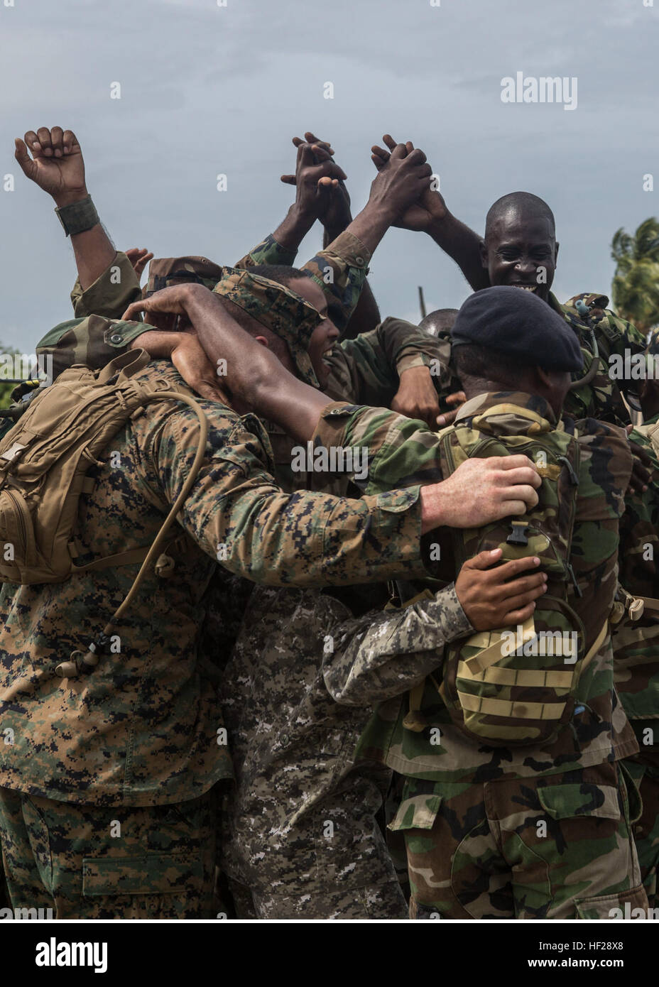 Personnel participating in Tradewinds 2014 cheer and hug one another over winning the squad competition to mark the final training day of the joint and combined exercise. Twelve teams comprised by one member of each partner nation competed for bragging rights in events like interior urban tactics training, interior close quarter battles and room clearings portion of the combined group competitions during Tradewinds 2014 aboard Dominican Naval Base, Las Calderas, located near Bani, Dominican Republic, June 24, 2014. U.S. Marines with Charley Company, 4th Law Enforcement Battalion, Marine Forces Stock Photo