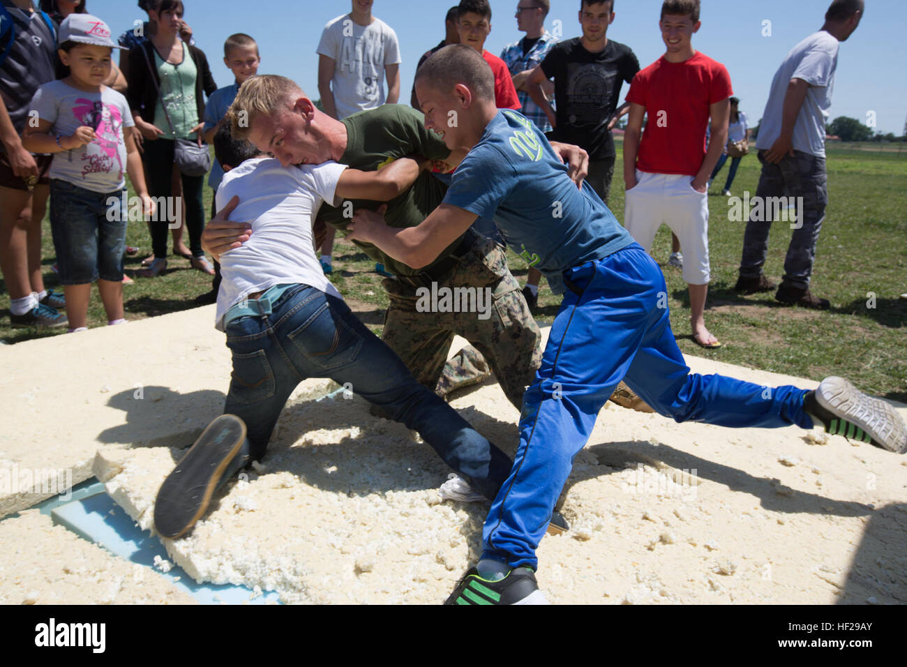 ... from 3rd Battalion, 8th Marine Regiment, plays with two Romanian boys while demonstrating MCMAP techniques during the last children's event ...