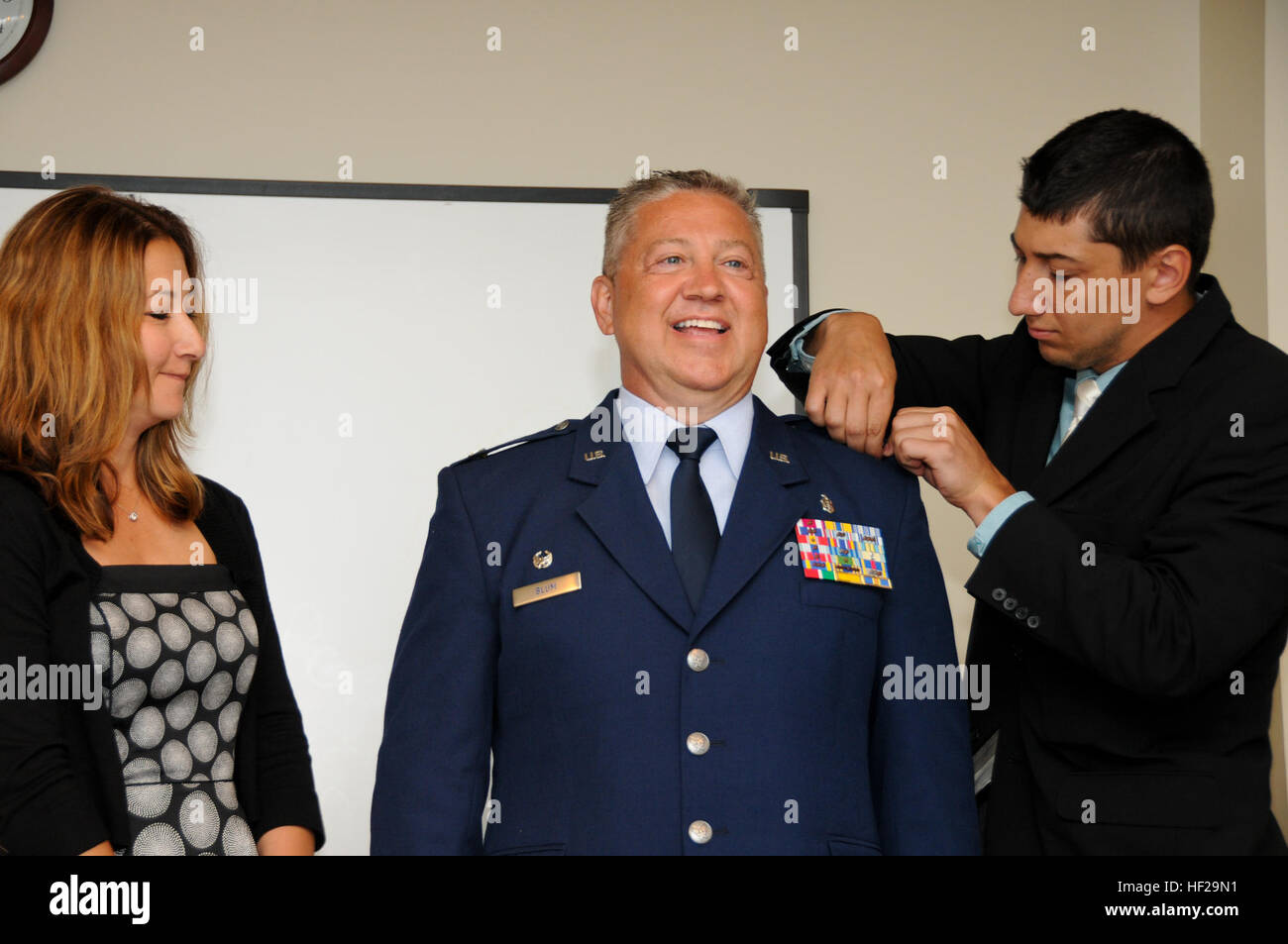 Newly promoted Col. Scott Blum, 108th Medical Group commander, stands proudly as his wife, Patricia, and son, Tyler, pin colonel rank on his service dress coat at his promotion ceremony at Joint Base McGuire-Dix-Lakehurst, N.J., July 7, 2014. (U.S. Air National Guard photo by Senior Airman Kellyann Novak/Released) Col. Blum's promotion ceremony 140707-Z-ME883-019 Stock Photo