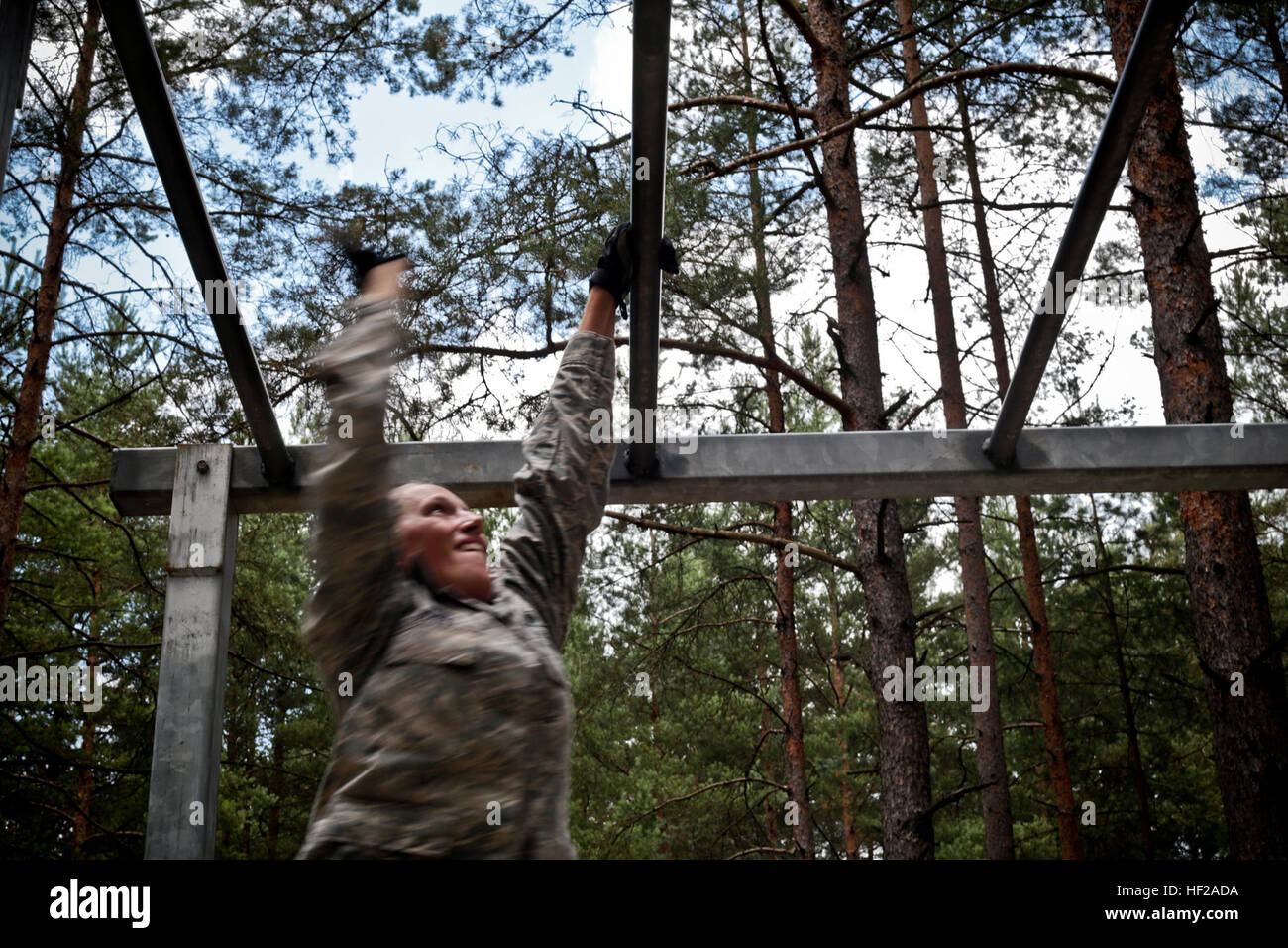 U.S. Air Force Staff Sgt. Alison Jones, with the 227th Air Support Operations Squadron, New Jersey Air National Guard (ANG), does the monkey bar challenge on an obstacle course at the Grafenwoehr Training Area in Bavaria, Germany, July 17, 2014, with Airmen with the 177th Fighter Wing, New Jersey ANG and the 124th Fighter Wing, Idaho ANG as part of joint training mission Operation Kriegshammer. (U.S. Air National Guard photo by Tech. Sgt. Matt Hecht/Released) Kriegshammer 140717-Z-NI803-479 Stock Photo