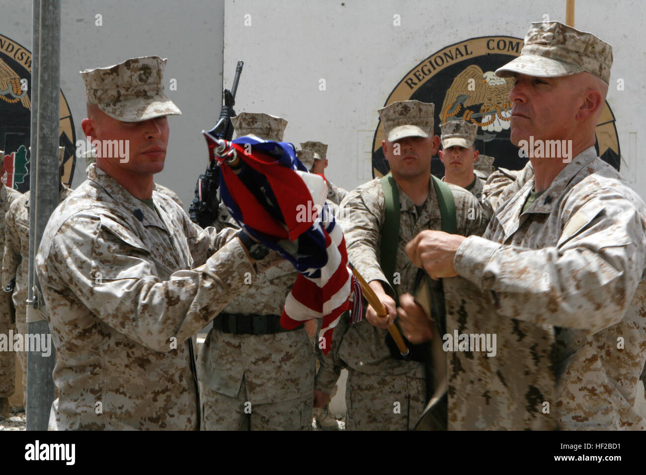 First Sgt. James J. Horr, left, senior staff noncommissioned officer of Brigade Headquarters Group - Afghanistan, and Lt. Col. Joseph J. Zarba, commanding officer of BHG-A, case the American flag during a ceremony for BHG-A aboard Camp Leatherneck, Afghanistan, July 25, 2014. Brigade Headquarters Group - Afghanistan deployed to Camp Leatherneck from Camp Pendleton, Calif., during December 2013 and January 2014 to provide administrative and logistical support to the Marines and sailors of Marine Expeditionary Brigade - Afghanistan and will redeploy at the end of July after completing a successf Stock Photo
