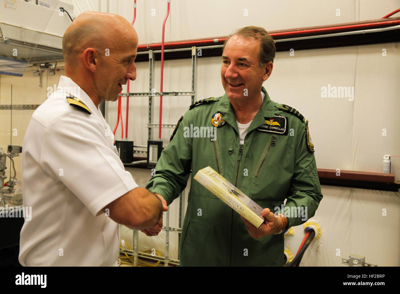 The First Sea Lord and Chief of Naval Staff of the British Royal Navy, Adm. Sir George Zambellas, right, receives a gift from a U.S. Navy captain during a visit at Naval Surface Warfare Center at Dahlgren, Va., July 29, 2014. Zambellas is taking part in the Commandant of the Marine Corps' Counterpart Program, which invites foreign military leaders to visit the United States and interact with U.S. military leaders. (U.S. Marine Corps photo by Cpl. Michael C. Guinto/Released) First Sea Lord Counterpart Visit 140729-M-LI307-457 Stock Photo