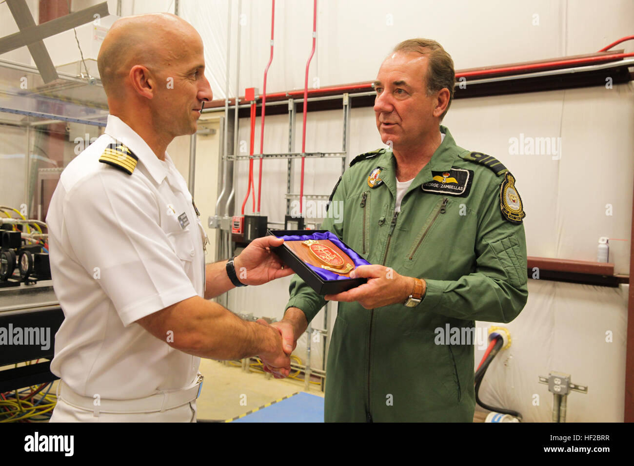 The First Sea Lord and Chief of Naval Staff of the British Royal Navy, Adm. Sir George Zambellas, right, presents a gift to a U.S. Navy captain during a visit at Naval Surface Warfare Center at Dahlgren, Va., July 29, 2014. Zambellas is taking part in the Commandant of the Marine Corps' Counterpart Program, which invites foreign military leaders to visit the United States and interact with U.S. military leaders. (U.S. Marine Corps photo by Cpl. Michael C. Guinto/Released) First Sea Lord Counterpart Visit 140729-M-LI307-459 Stock Photo