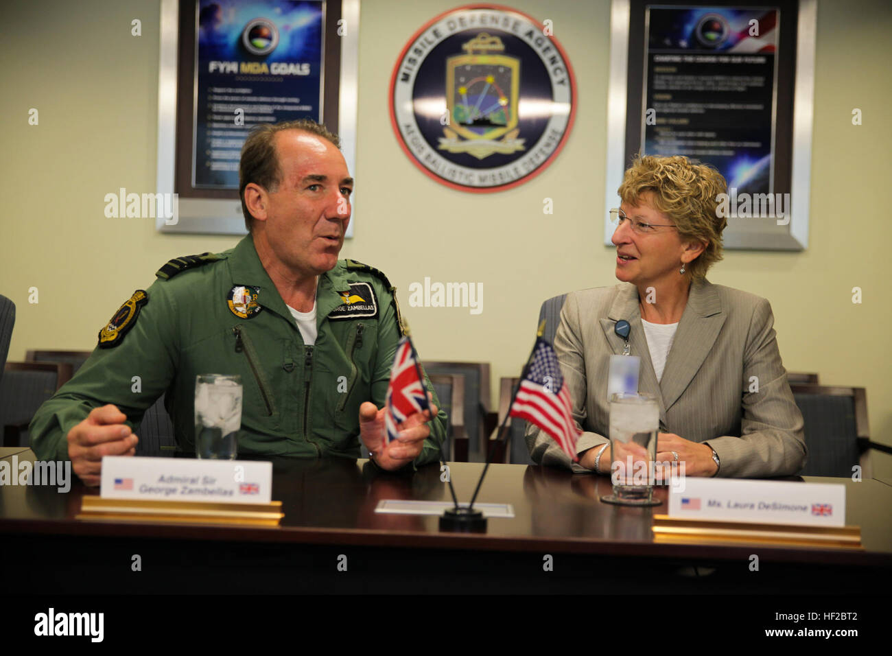 The First Sea Lord and Chief of Naval Staff of the British Royal Navy, Adm. Sir George Zambellas, left, attends a brief alongside Laura DeSimone at the Missile Defense Agency at Dahlgren, Va., July 29, 2014. Zambellas is taking part in the Commandant of the Marine Corps' Counterpart Program, which invites foreign military leaders to visit the United States and interact with U.S. military leaders. (U.S. Marine Corps photo by Cpl. Michael C. Guinto/Released) First Sea Lord Counterpart Visit 140729-M-LI307-484 Stock Photo