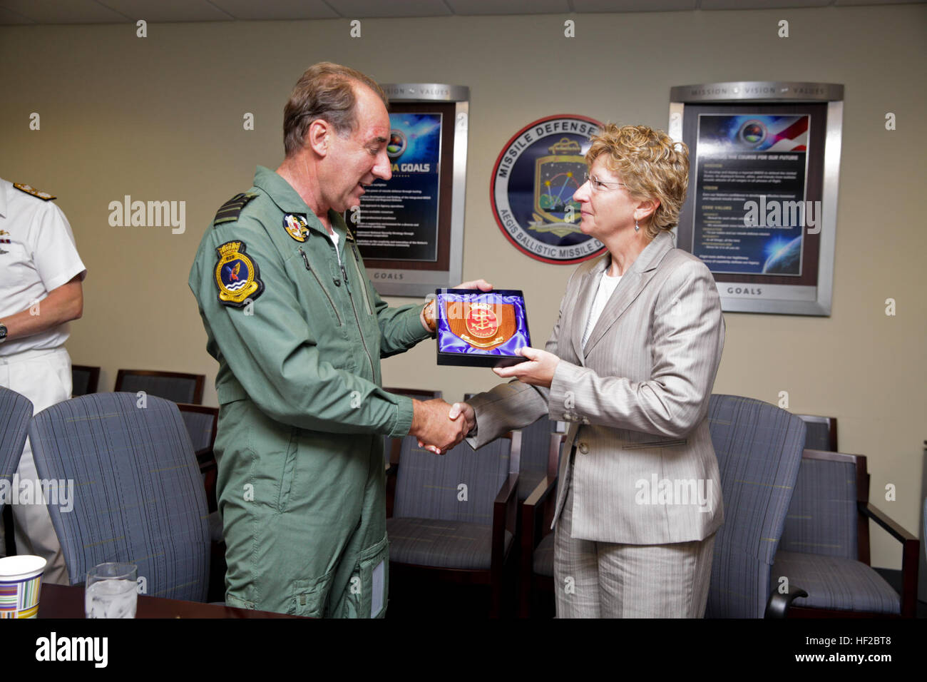 The First Sea Lord and Chief of Naval Staff of the British Royal Navy, Adm. Sir George Zambellas, left, presents a gift to Laura DeSimone at the Missile Defense Agency at Dahlgren, Va., July 29, 2014. Zambellas is taking part in the Commandant of the Marine Corps' Counterpart Program, which invites foreign military leaders to visit the United States and interact with U.S. military leaders. (U.S. Marine Corps photo by Cpl. Michael C. Guinto/Released) First Sea Lord Counterpart Visit 140729-M-LI307-488 Stock Photo