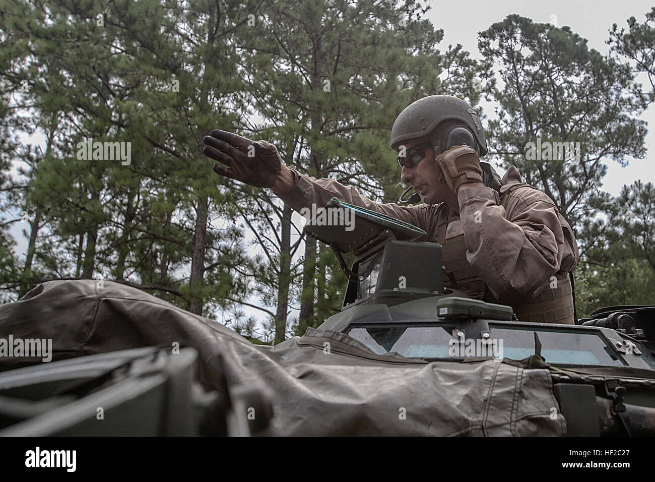 A Marine with 2nd Battalion, 10th Marine Regiment navigates with a map and gives directions to the driver of the Amphibious Assault Vehicle during an amphibious-assault, training mission on Onslow Beach aboard Marine Corps Base Camp Lejeune, North Carolina, July 31, 2014.  The mission consisted of transporting the Expeditionary Fire Support System inside the AAV's through the ocean, then back on land to a live-fire, mortar position to engage targets.  (U.S. Marine Corps photo taken by Lance Cpl. Alex W. Mitchell/released) EFSS teams conduct amphibious assaults, aerial raid training 140731-M-AM Stock Photo