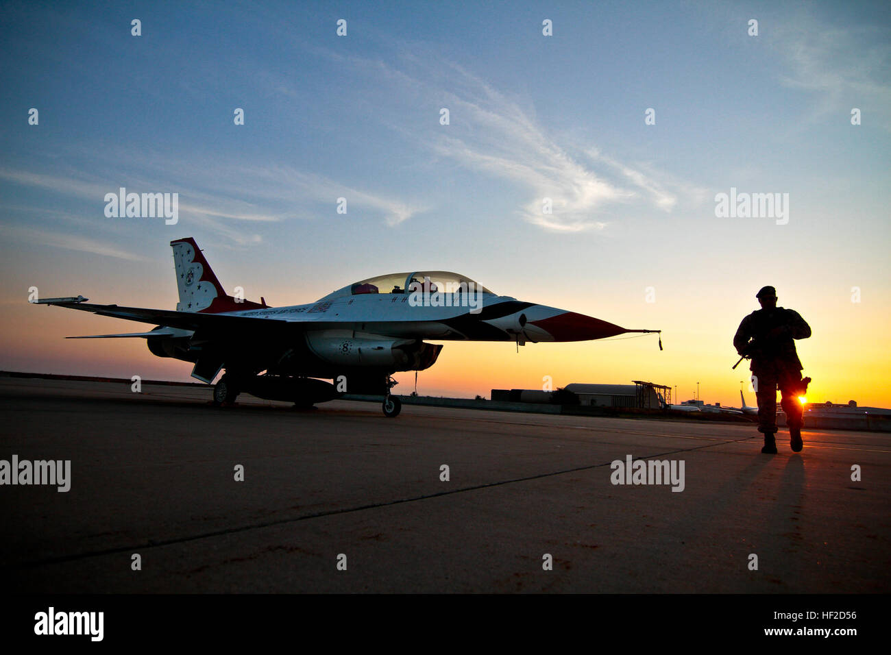 U.S. Air Force Staff Sgt. Luis Rodriguez from the New Jersey Air National Guard's 177th Security Forces Squadron does an early morning walk-around of U.S. Air Force F-16D Fighting Falcon #8 from the Thunderbirds Demonstration Team at Atlantic City Air National Guard Base, N.J., Aug. 11, 2014. The Thunderbirds are performing in N.J. for the Atlantic City 'Thunder Over the Boardwalk Airshow' Aug. 13.  (U.S. Air National Guard photo by Tech. Sgt. Matt Hecht/Released) Thunderbird at sunrise 140811-Z-NI803-022 Stock Photo