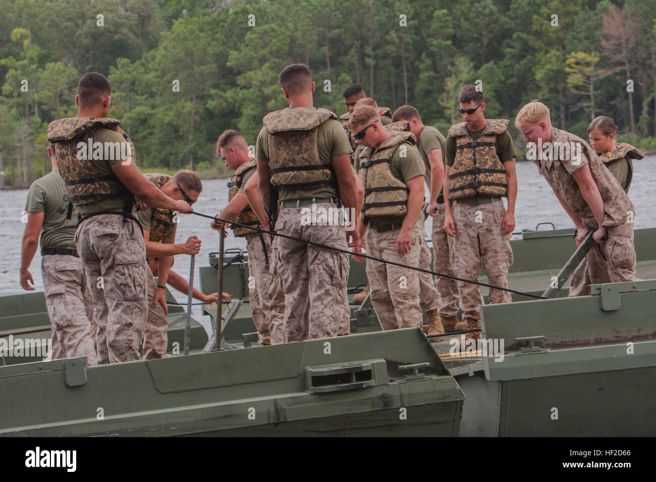 U.S. Marines with Bridge Company (Bridge Co.), 8th Engineer Support Battalion, 2nd Marine Logistics Group, connect interior bays in the water during improved ribbon bridging training on Camp Lejeune, N.C., August 11, 2014. Bridge Co. Marines used the bays to put together a continuous span that touched shore to shore for 2nd Tanks Battalion to cross using M1A1 Abrams Main Battle Tanks. (U.S. Marine Corps photo by Lance Cpl. Desire M. Mora/Released) Bridge Company Marines conduct training with 2nd Tanks Battalion 140811-M-TG562-222 Stock Photo