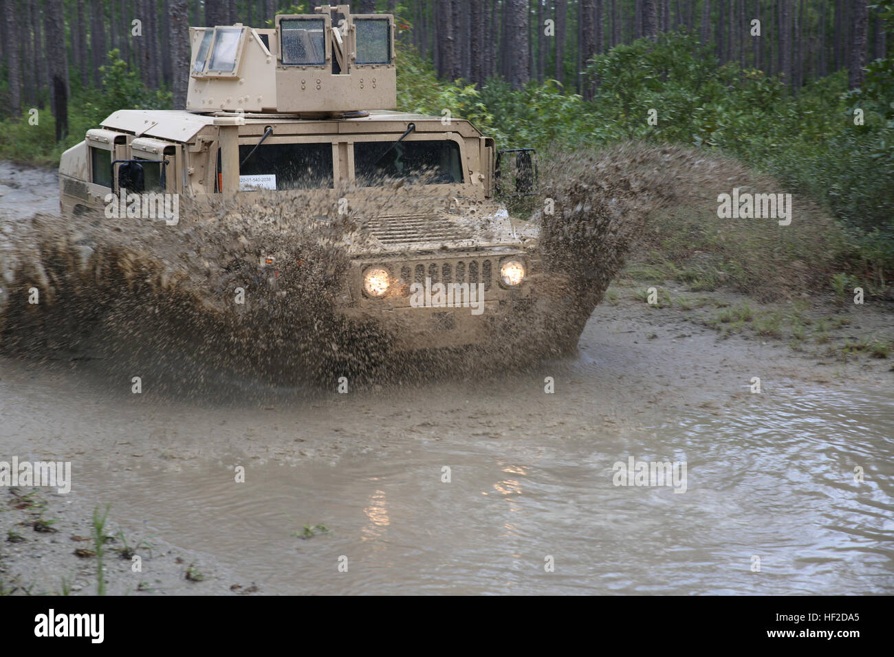 A Marine drives a Humvee through a four-foot water-fording obstacle at ...
