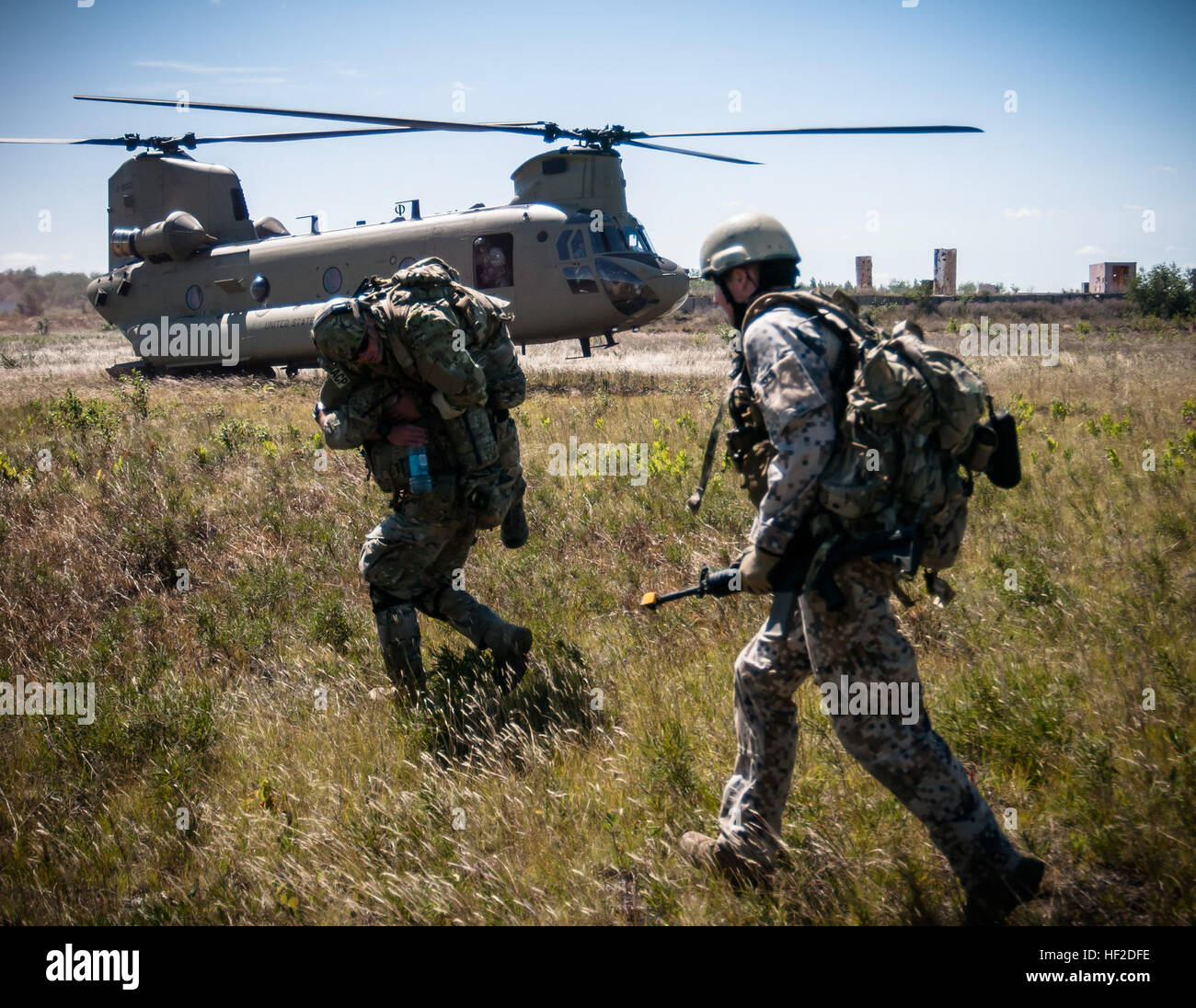 Tactical air control party members from the Latvian armed forces and the 169th Air Support Operations Squadron in Peoria, Ill., fireman-carry a wounded Airman to a waiting CH-47 Chinook helicopter from 3-238th General Support Aviation Battalion, Grand Ledge, Mich., during Operation Northern Strike 2014 near Grayling, Mich., Aug. 14, 2014. Operation Northern Strike 2014 is a joint multinational combined arms training exercise conducted in Michigan. (U.S. Air National Guard photo by Master Sgt. Scott Thompson/released) Operation Northern Strike 2014 140814-Z-GS745-1329 Stock Photo