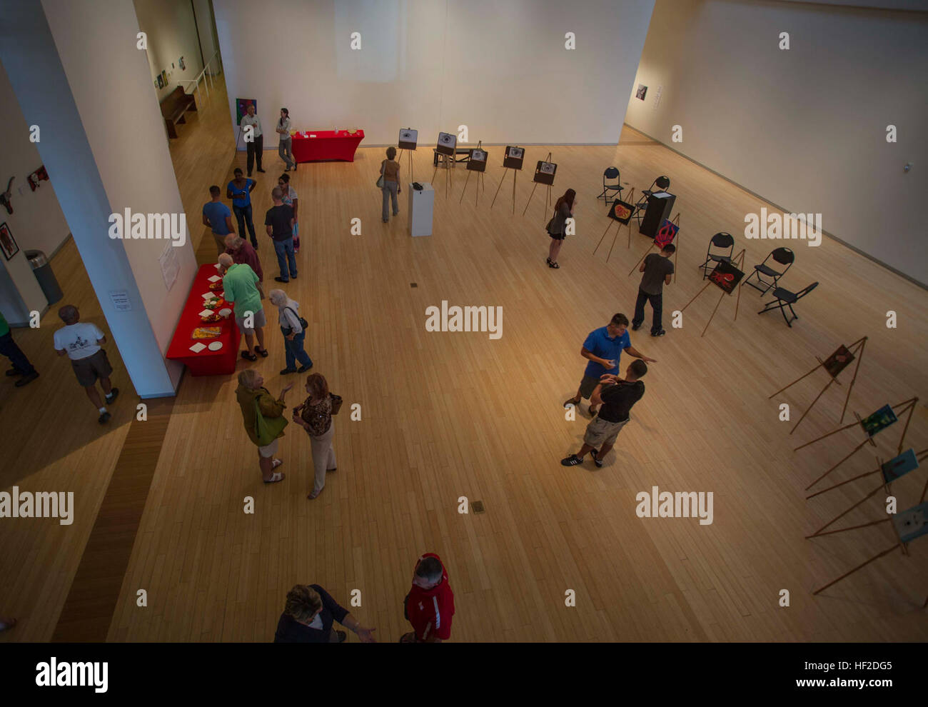 Marines, sailors, family members and guests talk about and look at the