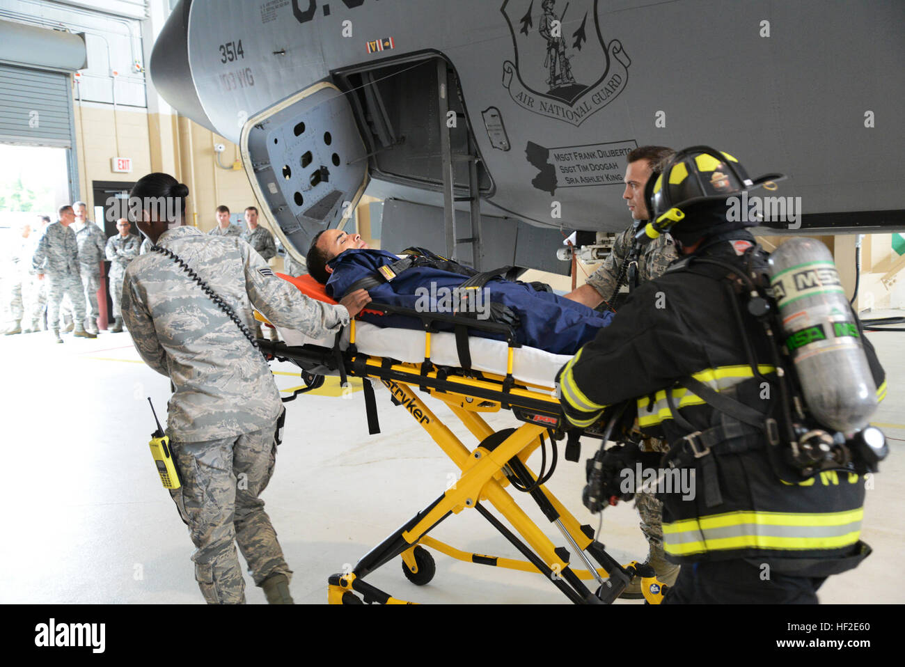 Airman 1st Class Leonardo Lantigua-Menendez, 108th Wing Maintenance Squadron, is wheeled away from the scene where he was extracted from a fuel tank. Airmen from the 108th Maintenance Squadron, 108th Wing, New Jersey Air National Guard, perform a fuel tank extraction to test the procedures to extract an unconscious victim from a KC-135R Stratotanker fuel tank at Joint Base McGuire-Dix-Lakehurst, N.J., Aug. 22, 2014. The exercise involved multiple Joint Base organizations including the 108th Wing and the 87th Bio-Environmental shops, the 87th Fire Department and both the 108th and the 87th Safe Stock Photo