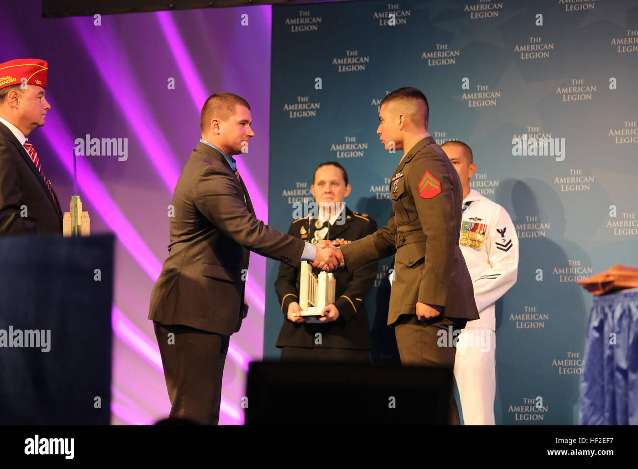 Army Sgt. Kyle White, Medal of Honor recipient, left, shakes hands with Cpl. Ricardo Gonzalez during the American Legion’s 96th National Convention in Charlotte, N.C., Aug. 26, 2014. Gonzalez was awarded the Spirit of Service Award for his exceptional contributions to his local community through volunteer efforts off-duty.  Gonzalez is a Marine Air-Ground Task Force planning specialist with 4th Marine Regiment at Camp Schwab, Okinawa, Japan. Marine awarded American Legion Spirit of Service Award 140826-M-SR938-223 Stock Photo