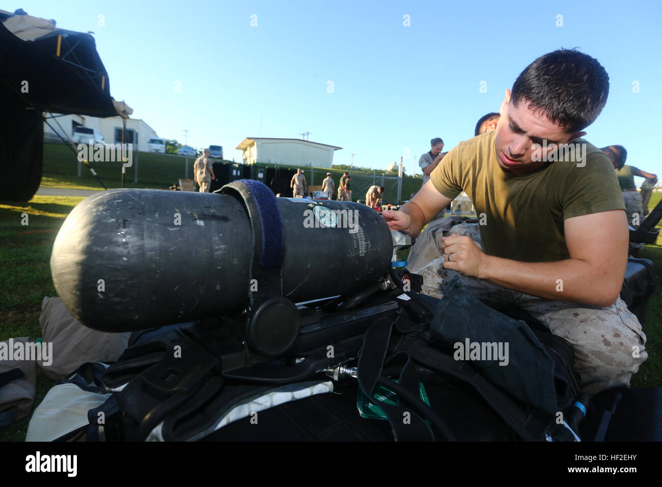 U.S. Marine Corps Lance Cpl. Robert Tausendfredt, with Chemical, Biological, Radiological, and Nuclear Platoon, 1st Marine Aircraft Wing attaches his oxygen tank and his mission oriented protective posture together during a hazardous incident response training exercise on Marine Corps Air Station Futenma, Okinawa, Japan, Aug. 27, 2014. The training was conducted as part of Ulchi Freedom Guardian 14, a combined military exercise between South Korea and the United States, to help Marines practice casualty evacuation and decontamination of individuals in chemically contaminated environments. (U.S Stock Photo