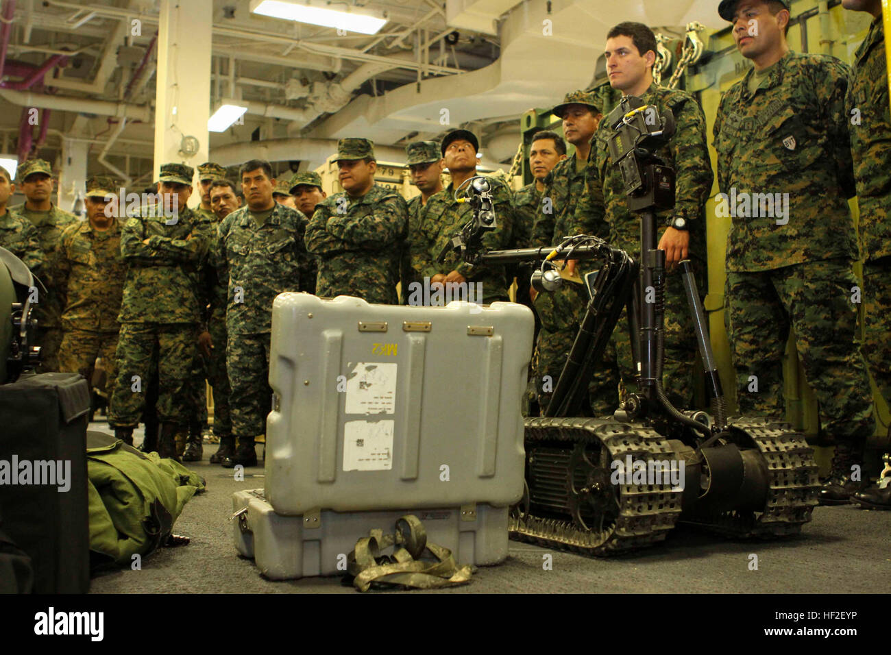 Peruvian Marines gather around explosive ordnance disposal equipment at a  static display during a tour aboard the future amphibious assault ship USS  America (LHA 6) in Peru, Sept. 1, 2014. The tour