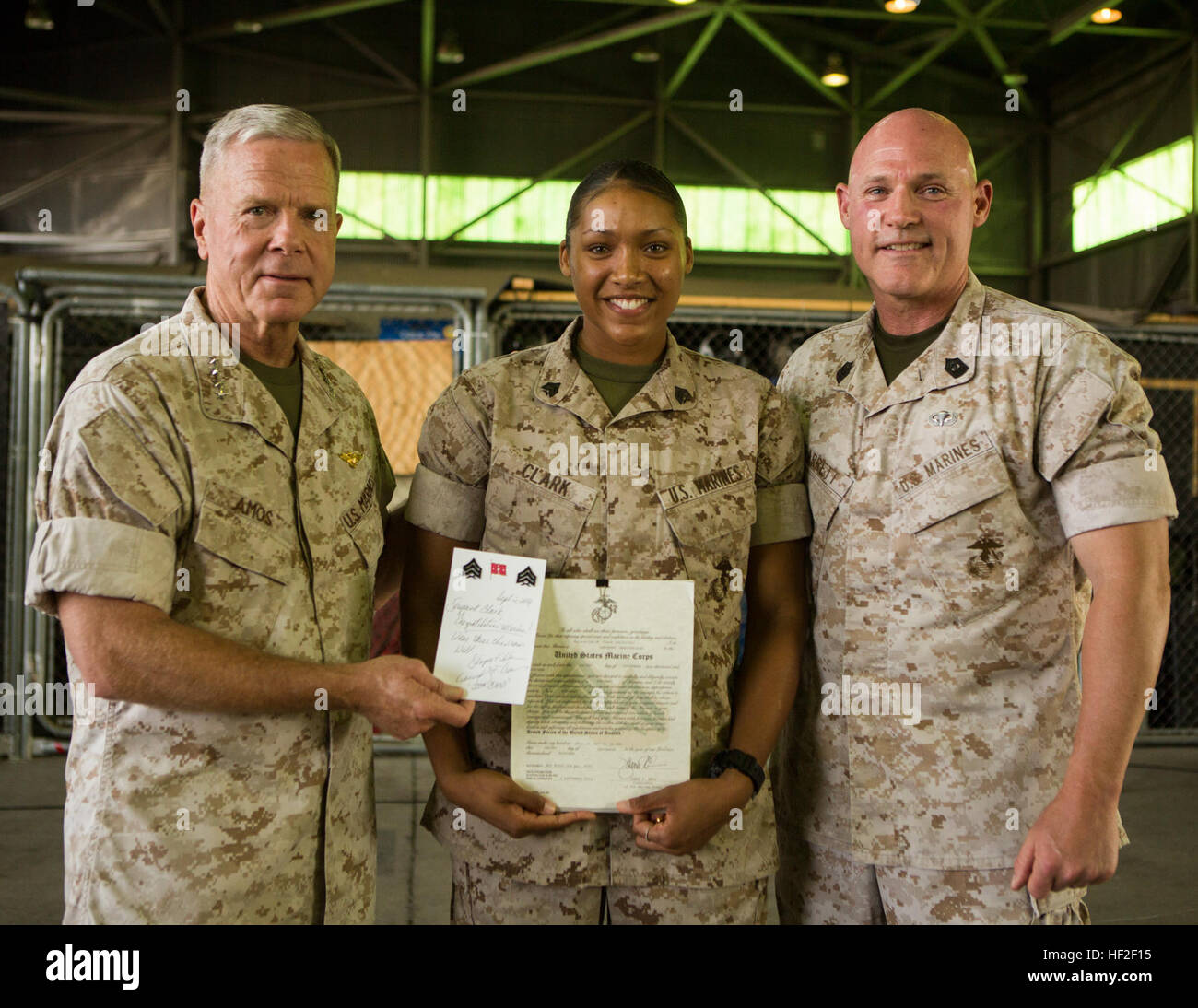 (From left to right) U.S. Marine Corps Gen. James F. Amos, 35th commandant of the Marine Corps, Sgt. Malachijah Clark an avation supply specialist with Special-Purpose Marine Air Ground Task Force Crisis Response (SP-MAGTF Crisis Response), and Sgt.Maj. Micheal P. Barrett, 17th sergeant major of the Marine Corps pose for a photo after promoting Clark from Corporal to Sergeant aboard Morón Air Base, Spain, Sept. 2, 2014. The general and sergeant major spoke to the Marines and Sailors about the significance of SP-MAGTF Crisis Response. SP-MAGTF Crisis Response is a rotational force of Marines an Stock Photo