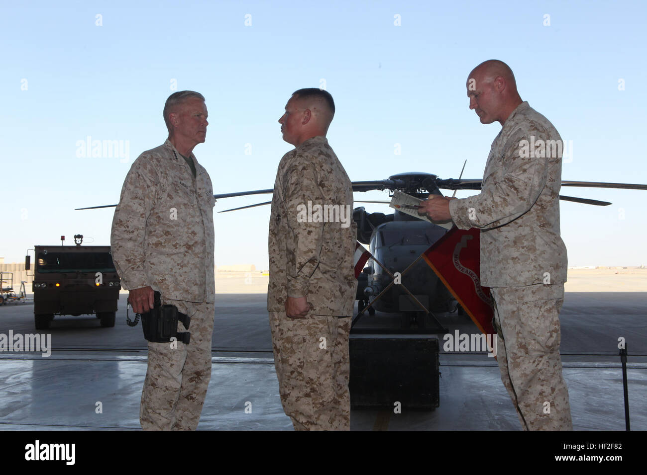 Sergeant Maj. Micheal Barrett, right, the 17th Sergeant Major of the Marine  Corps, reads the meritorious promotion warrant of Lance Cpl. Matthew Padilla, an airframe mechanic with Marine Aviation Logistics Squadron 70, Marine Aircraft Group - Afghanistan, during his meritorious promotion ceremony aboard Camp Leatherneck, Afghanistan, Sept. 6, 2014. General James F. Amos, the 35th Commandant of the Marine Corps, meritoriously promoted Padilla, a native of Littleton, Colo., to the rank of corporal during his final visit to Helmand province. Commandant, Sergeant Major of the Marine Corps visit M Stock Photo
