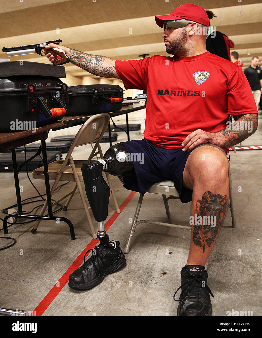 Sgt. Andres Burgos from Orlando, Florida, aims down range during shooting practice for the Marine team, September 24, in preparation for the 2014 Warrior Games. The Marine team has been training since September 15 in order to build team cohesion and acclimate to the above 6,000 ft. altitude of Colorado Springs. The Marine team is comprised of both active duty and veteran wounded, ill and injured Marines who are attached to or supported by the Wounded Warrior Regiment, the official unit of the Marine Corps charged with providing comprehensive non-medical recovery care to wounded, ill and injure Stock Photo