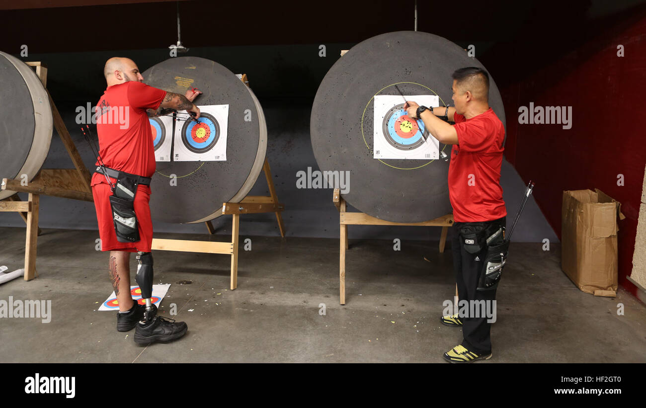 Capt. Chris McGleinnaiss, from Kailua, Hawaii, and teammate Sgt. Andres Burgos, from Orlando, Florida, remove arrows from their targets during archery practice for the Marine team, September 25, in preparation for the 2014 Warrior Games. The Marine team has been training since September 15 in order to build team cohesion and acclimate to the above 6,000 ft. altitude of Colorado Springs.  The Marine team is comprised of both active duty and veteran wounded, ill and injured Marines who are attached to or supported by the Wounded Warrior Regiment, the official unit of the Marine Corps charged wit Stock Photo