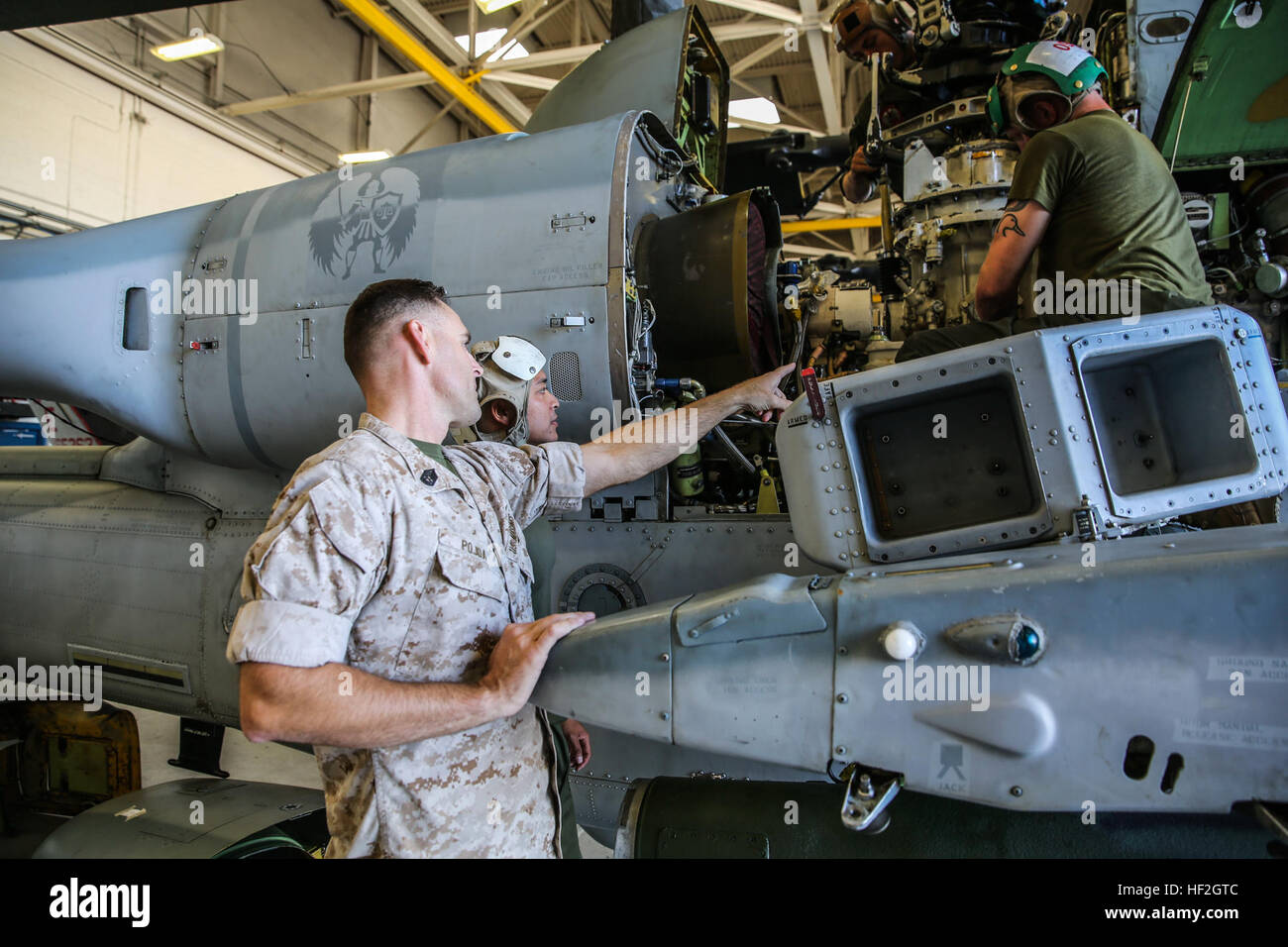 Gunnery Sgt. Stephen Pojda from Modesto, Calif., the quality assurance chief for Marine Light Attack Helicopter Squadron 469, Marine Aircraft Group 39, 3rd Marine Aircraft Wing, I Marine Expeditionary Force, supervises Marines performing maintenance on a damaged aircraft aboard Marine Corps Air Station Camp Pendleton, Calif., Sept. 25, 2014. Quality assurance Marines ensure that maintenance is done safely, effectively, and in accordance with relevant regulations. (U.S. Marine Corps photo by Lance Cpl. Caitlin Bevel) Quality assurance maintains Marines' safety 140925-M-MP944-010 Stock Photo