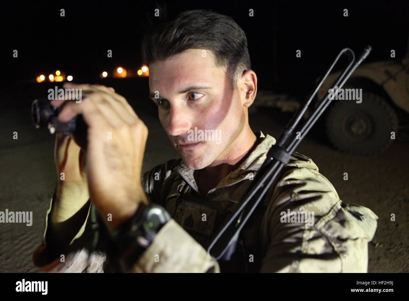 Sergeant Dominic Sharpsteensurina, a native of Apple Valley, California, and an assault section leader with Weapons Platoon, Charley Company, 1st Battalion, 7th Marine Regiment, inspects his PVS-14 night vision system aboard Camp Dwyer, Helmand province, Afghanistan, Sept. 21, 2014. During his current deployment in Afghanistan, Sharpsteensurina was meritoriously promoted to the rank of sergeant. He is glad to be able to take part in Operation Enduring Freedom with his fellow infantrymen and become someone they can look up to. (U.S. Marine Corps photo by Cpl. Cody Haas/ Released) Charley Compan Stock Photo