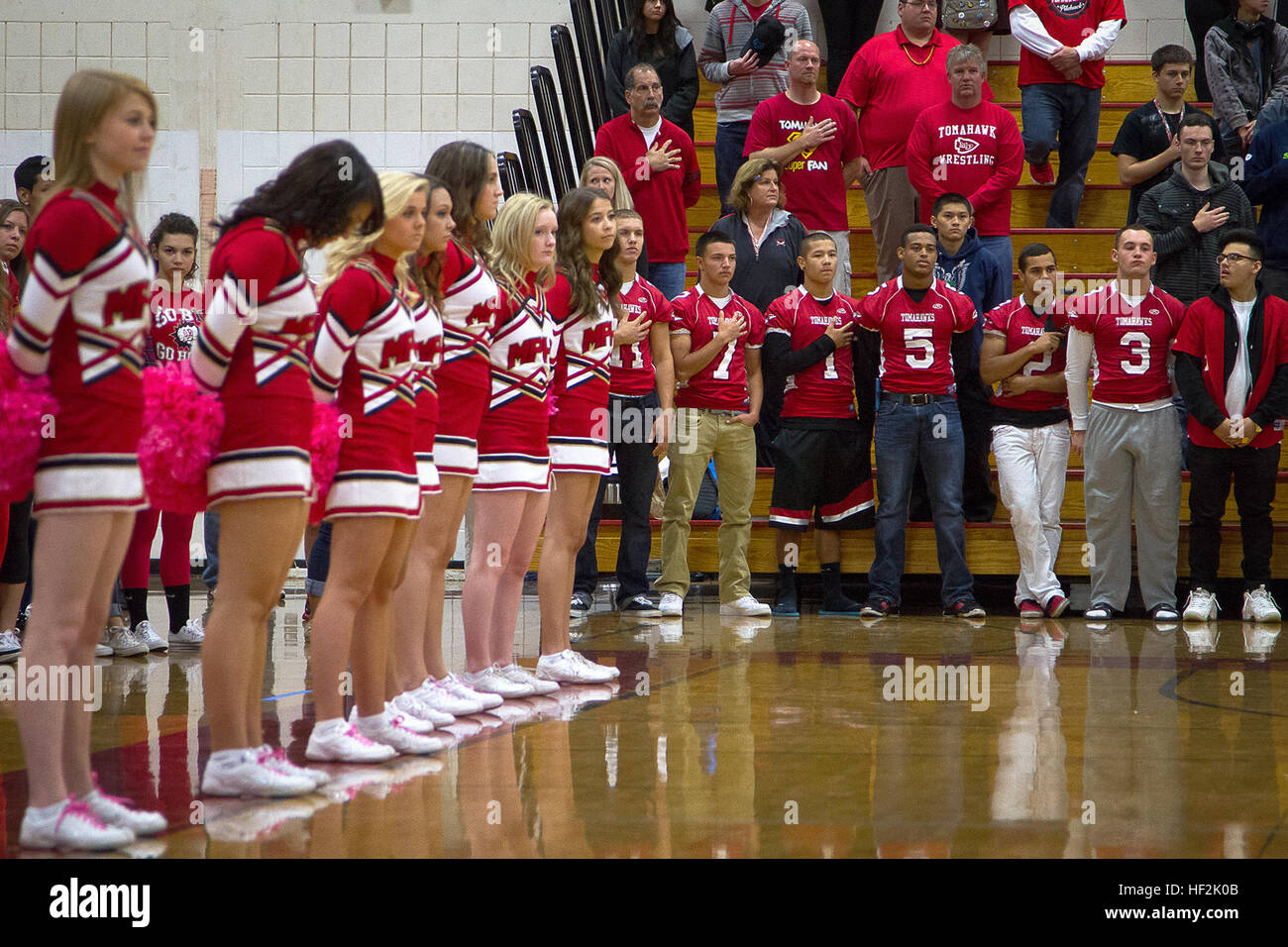 Austin Joyner (jersey number five), a cornerback for the Marysville-Pilchuck High School Tomahawks and 17-year-old native of Marysville, Wash., and classmates honor the national anthem before Joyner received his Semper Fidelis All-American Bowl jersey from Seattle-based Marines during an assembly at Marysville-Pilchuck High School in Marysville, Oct. 17, 2014. Joyner is among approximately 100 student athletes from across the nation selected to participate in the game at the StubHub Center in Carson, Calif., Jan. 4, 2015. He joins Yakima’s West Valley High School football star Shane Lemieux as Stock Photo