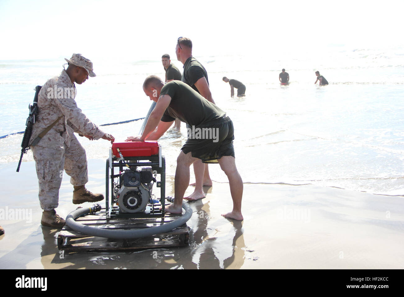 Marines with Marine Wing Support Squadron 373 prime the pump to feed water to the Tactical Water Purification System during exercise Pacific Horizon 2015 at Marine Corps Base Camp Pendleton, Calif., Oct. 22. PH 15 increases the ability of 1st Marine Expeditionary Brigade and Expeditionary Strike Group 3 to plan, communicate and conduct complex sea and shore based operations in response to natural disasters. (U.S. Marine Corps photo by Lance Cpl. Caitlin Bevel) Marines recycle the surf for Pacific Horizon 141022-M-MP944-033 Stock Photo