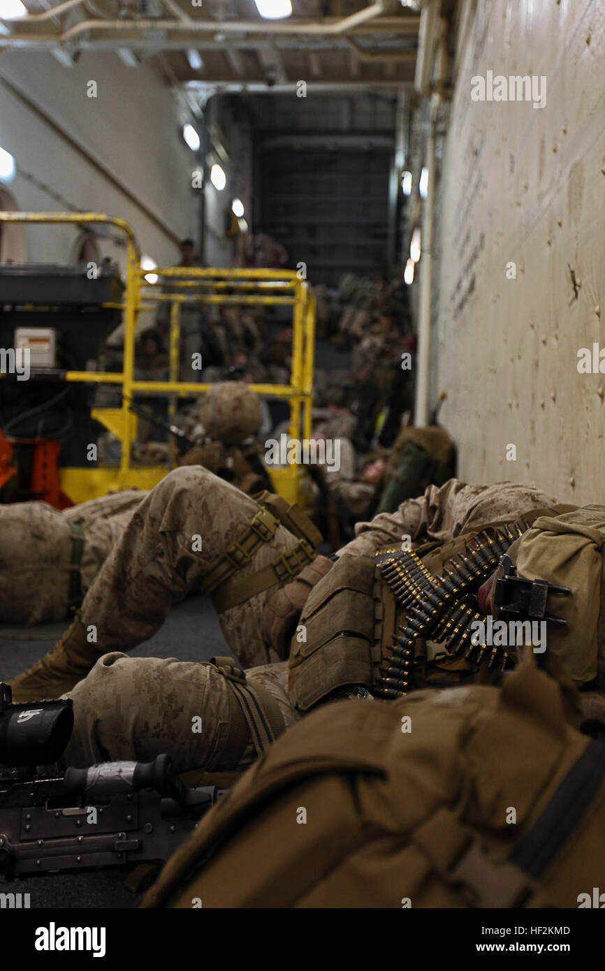 A 24th Marine Expeditionary Unit Marine with Battalion Landing Team 3rd Battalion, 6th Marine Regiment, sleeps on the ramp of the USS New York while waiting to conduct an amphibious assault exercise, Oct. 26, 2014. The entire contingent of Marines from the BLT disembarked from the New York to participate in the assault, the final event of the MEU’s pre-deployment training before their deployment at the end of the year. (U.S. Marine Corps photo by 1st Lt. Joshua W. Larson) A Week at Sea Aboard the USS New York 141026-M-FR139-137 Stock Photo