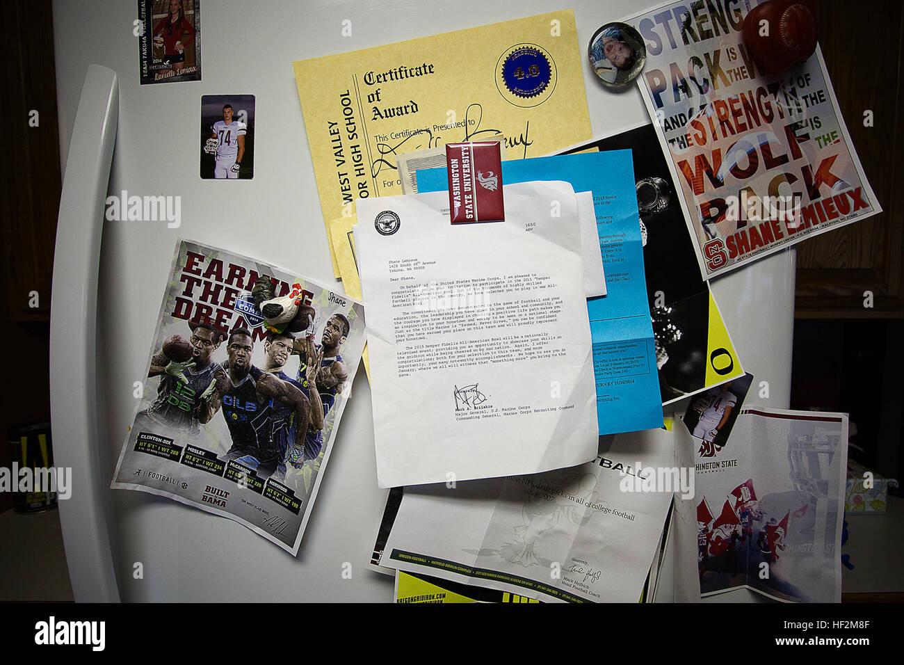 A letter (center) from Maj. Gen. Mark Brilakis, the commanding general of Marine Corps Recruiting Command, inviting Shane Lemieux, a offensive tackle for the West Valley High School Rams varsity football team, to play in the 2015 Semper Fidelis All-American Bowl hangs among college football recruitment flyers on the Lemieux family fridge at their home in Yakima, Wash., Oct. 31, 2014. Lemieux, a 17-year-old University of Oregon commit, is among approximately 100 student athletes from across the nation selected to participate in the game at the StubHub Center in Carson, Calif., Jan. 4, 2015. He  Stock Photo