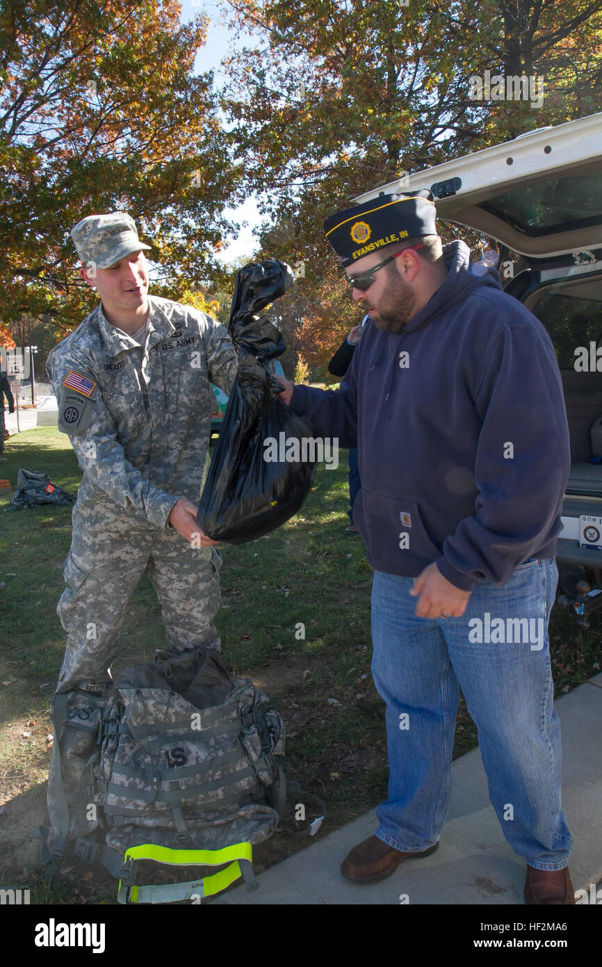 Cadet Joshua Orcutt, student at Westpoint prep school, hands over the canned goods he used as weight in his rucksack during the Norwegian Foot March at the University of Southern Indiana Nov 1. The food will benefit the Lucas Place II, a shelter for homeless veterans in Evansville, Ind. (U.S. Army photo by Sgt. Katherine M. Forbes) Norwegian Foot March breaks record with over 700 participants 141101-Z-MS942-151 Stock Photo