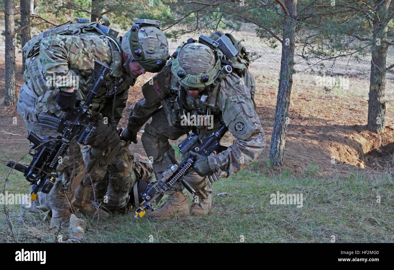 Soldiers assigned to the 1st Brigade Combat Team, 1st Cavalry Division, carry a simulated casualty to a fortified, safe position during a room clearing exercise as part of Iron Sword 2014 on Nov. 4,2014.  This exercise is part of the U.S. Army Europe-led Operation Atlantic Resolve land force assurance training taking place across Estonia, Latvia, Lithuania and Poland to enhance multinational interoperability, strengthen relationships among allied militaries, contribute to regional stability and demonstrate U.S. commitment to NATO. (U.S. Army photo by Spc. Seth LaCount, 126th Press Camp, Michig Stock Photo