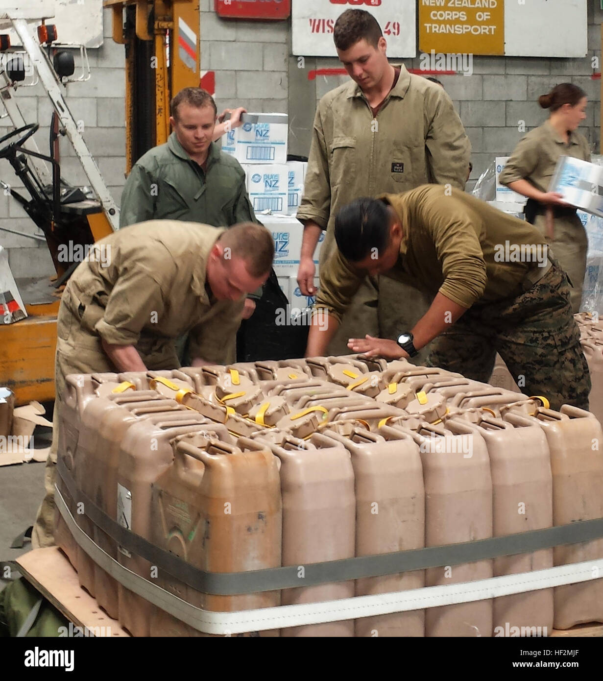 U.S. Marines with 1st Transportation Support Battalion, Combat Logistics Regiment 1, and New Zealand Defense Force soldiers with Air Delivery Platoon, 5th Movement Co., prepare 5-gallon jugs of water for an air drop  from a C-130 'Hercules' aircraft during Exercise Kiwi Koru 2014  on Nov. 5, 2014. Kiwi Koru is an interopability exercise centered in the pacific which allows U.S. forces to interact and learn with their Kiwi counterparts. (Courtesy photo by Stephen Sheppard/ Released) Marines, New Zealand Soldiers conduct airdrops during Exercise Kiwi Koru 2014 141105-M-UK001-230 Stock Photo