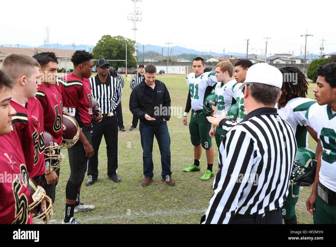 Col. Robert Boucher, commanding officer of Marine Corps Air Station Iwakuni, Japan, flips the coin to begin the 2014 Department of Defense Dependents Schools Far East Division II Football Championship Game at the Matthew C. Perry High School football field aboard MCAS Iwakuni Nov. 8, 2014. The Daegu Warriors won the toss and went on to defeat the M. C. Perry Samurai 60-50. Warriors outlast Samurai 60-50 in championship game 141108-M-RQ061-088 Stock Photo