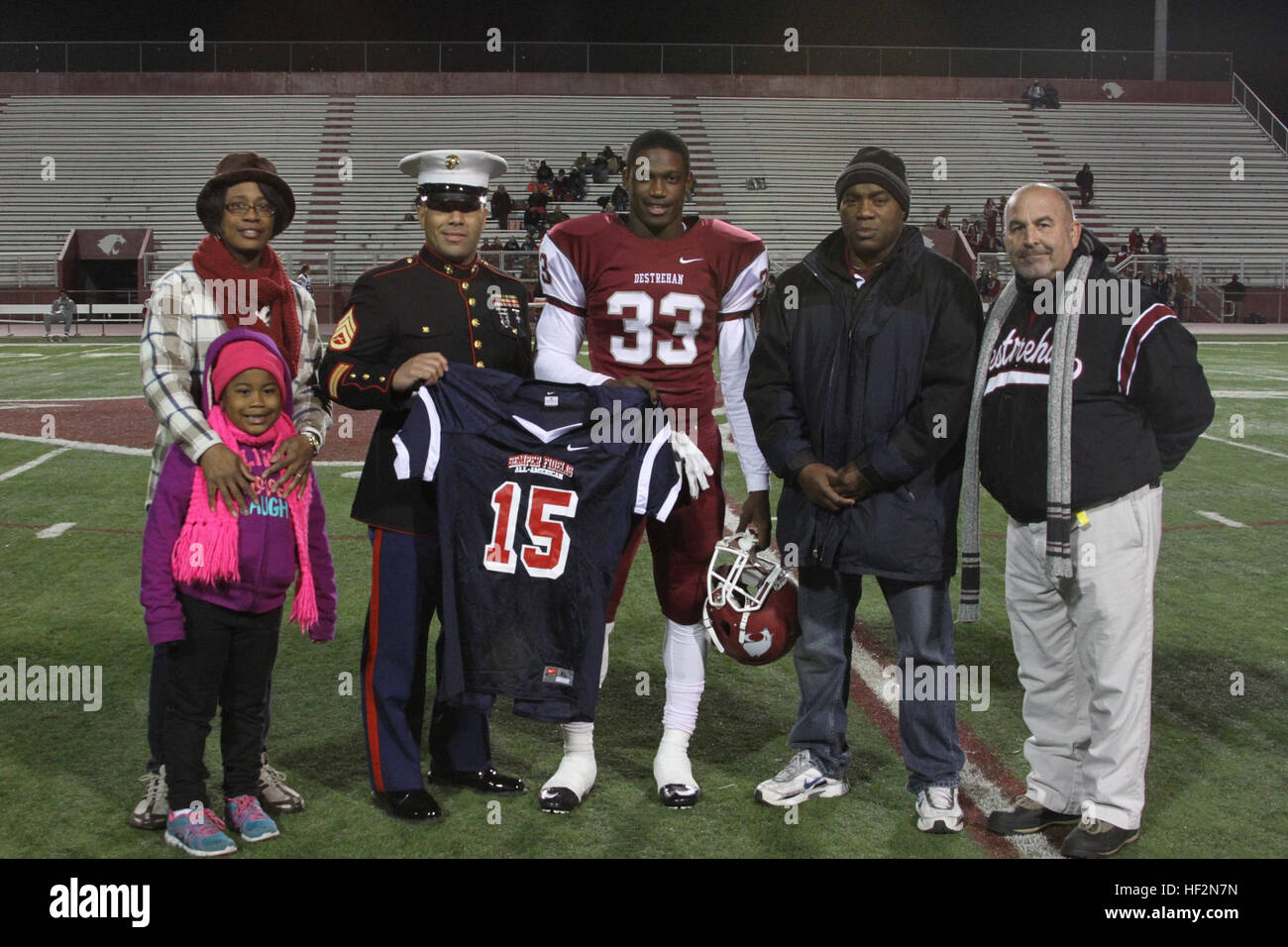 Kirk Merritt, an athlete from the Destrehan High School football team, is presented a jersey for being selected to play in the Semper Fidelis All-American Bowl on Jan. 4, 2015. The jersey was presented by Marine Corps Recruiter Staff Sgt. Carlos Pineda with the attendance of Kirk’s parents and his coach during the Destrehan vs Pineville football game on Nov. 14. Kirk Merritt selected for SFAAB 141114-M-YE163-001 Stock Photo