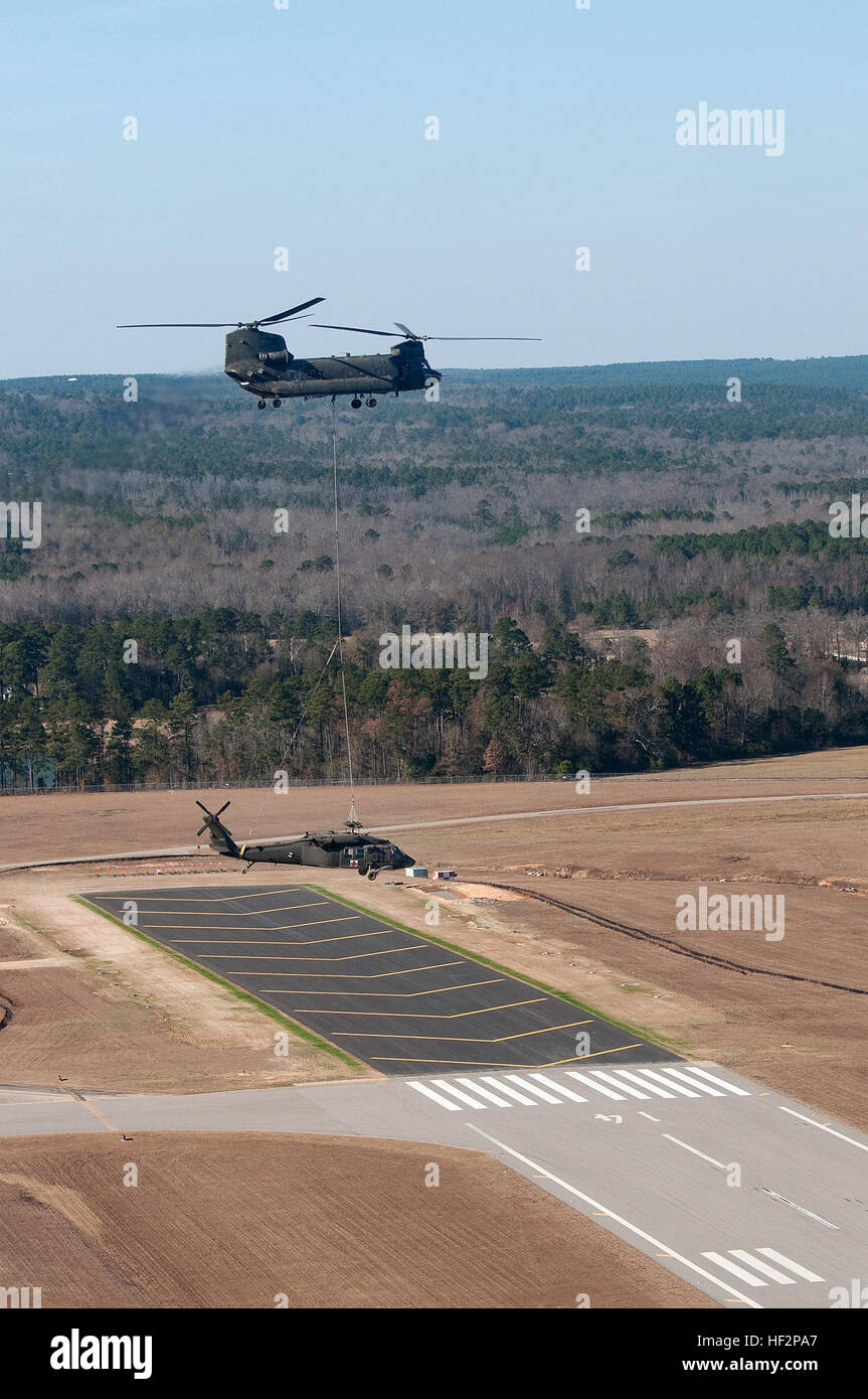 U.S. Soldiers from the South Carolina Army National Guard work to prepare a UH-60 Black Hawk from Detachment 2, Company F, 1-171st General Support Aviation Battalion, South Carolina Army National Guard, for sling-load movement to McEntire Joint National Guard Base, Eastover, S.C., Dec. 7, 2014. The Black Hawk made an emergency landing in an open field Dec. 3, 2014, due to a main rotor blade malfunction in Columbia, S.C. The Black Hawk was released by the Accident Review Board for recovery and was being transported via sling-load under a South Carolina Army National Guard CH-47 Chinook helicopt Stock Photo