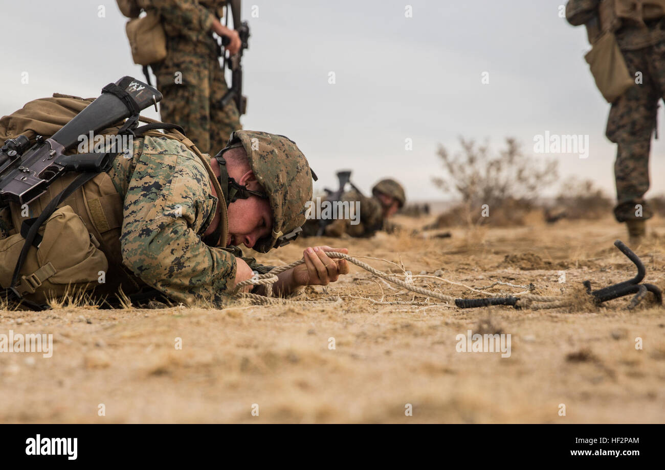 U.S. Marine Lance Cpl. Garrett Johnson retrieves a grappling hook while conducting lane clearing during a combined arms exercise aboard Marine Corps Air Ground Combat Center, Twentynine Palms, Calif., Dec. 8, 2014.  Johnson is a combat engineer with Battalion Landing Team 3rd Battalion, 1st Marine Regiment, 15th Marine Expeditionary Unit. BLT 3/1 conducted this training concurrent with the 15th MEU’s realistic urban training.  RUT prepares the 15th MEU’s Marines for their upcoming deployment, enhancing their combat skills in environments similar to those they may find in future missions. (U.S. Stock Photo