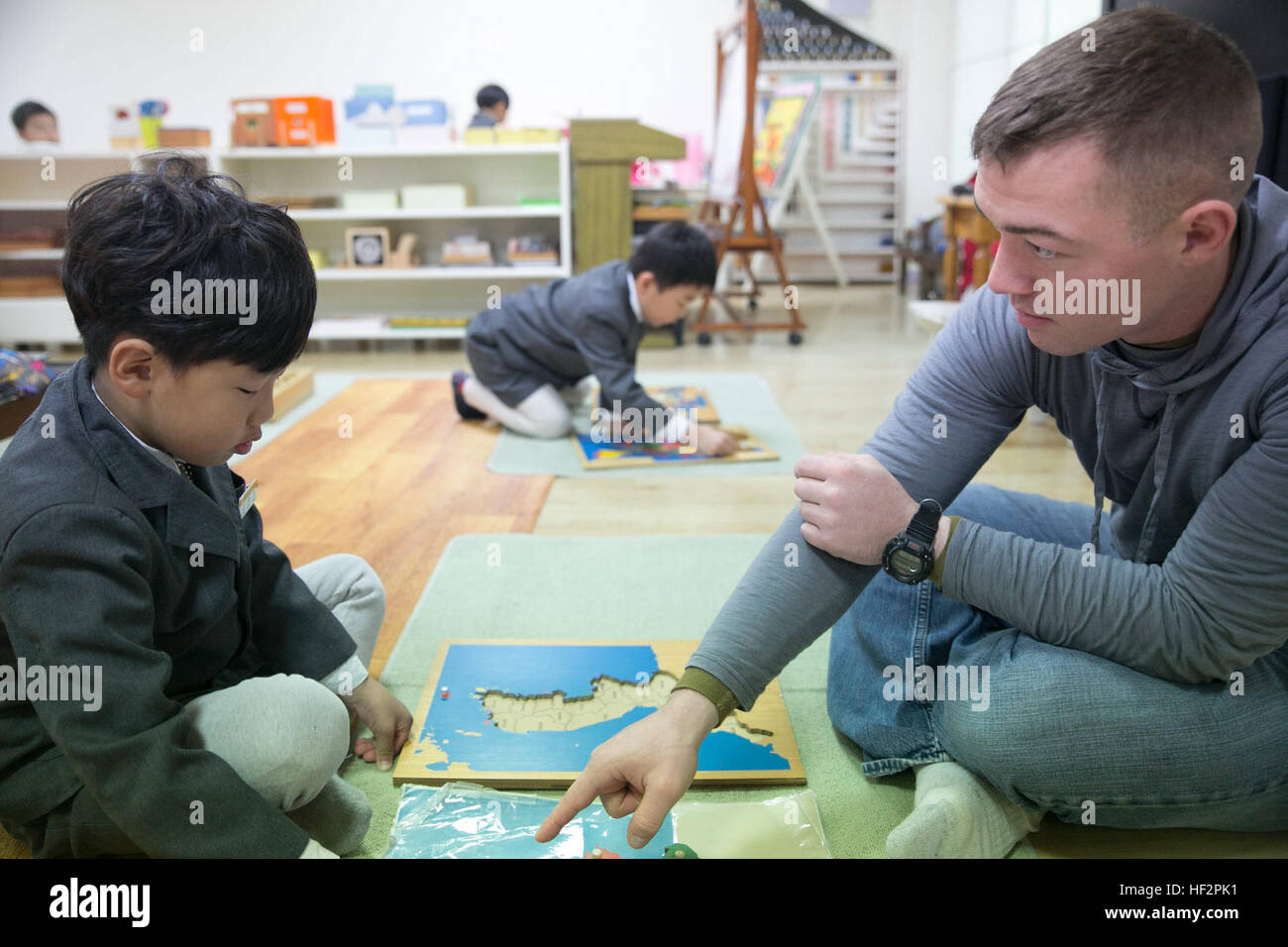 Sgt. Joshua Krutz builds a map with a student from St. Paul’s Elementary School in Pohang, South Korea. The meeting was brought on by a volunteer opportunity for the Marines and sailors of 2nd Battalion, 9th Marine Regiment, who are currently deployed to the Republic of Korea for Korean Marine Exchange Program 15-15. The volunteer opportunity supported the local area outside of Camp Mujuk and built better community relations. Krutz is a squad leader with Company G, 2nd Bn., 9th Marines, currently assigned to 3rd Marine Division, III Marine Expeditionary Force, under the unit deployment program Stock Photo