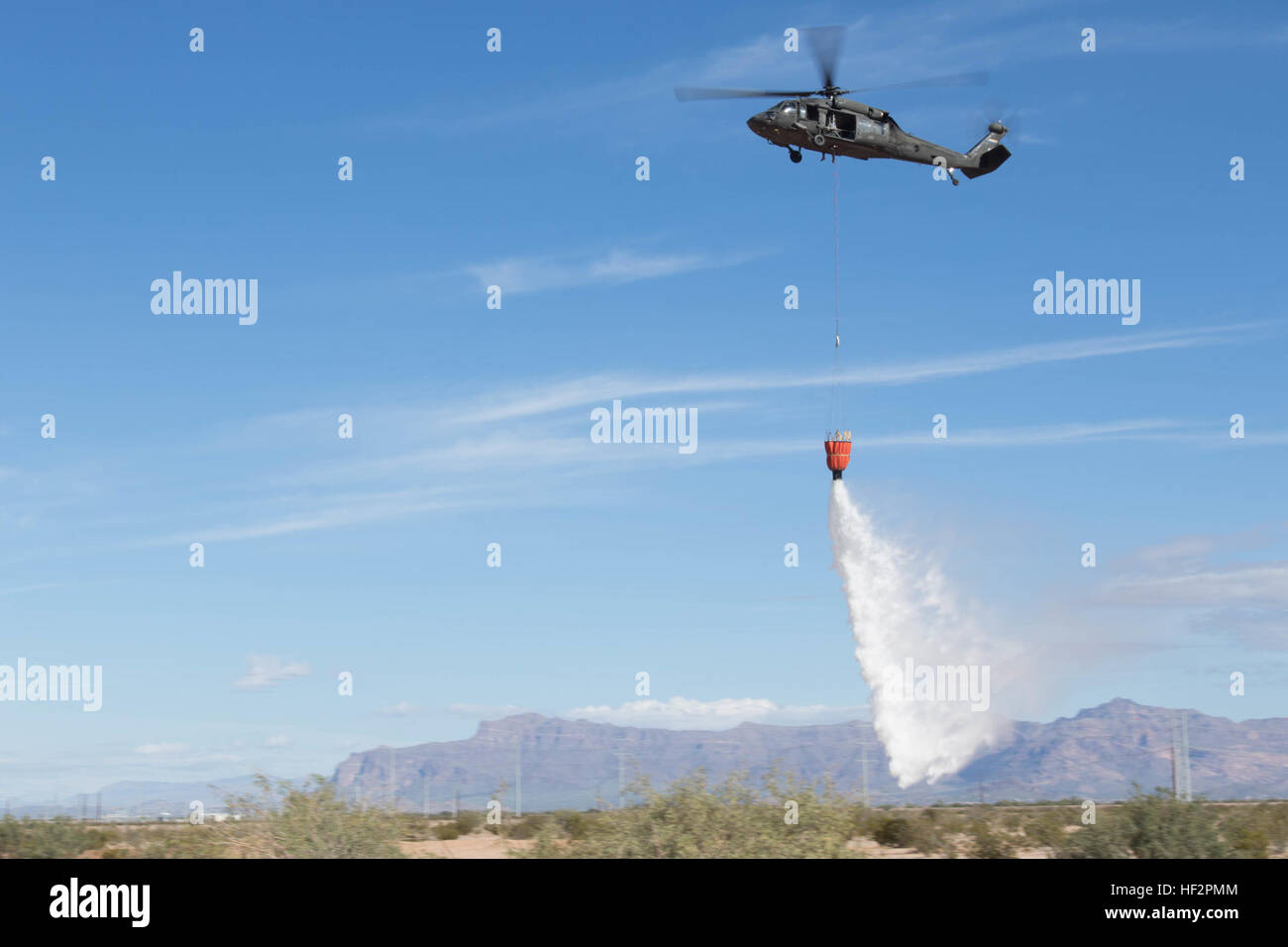 Water is released from a Bambi Bucket suspended under an Arizona Army