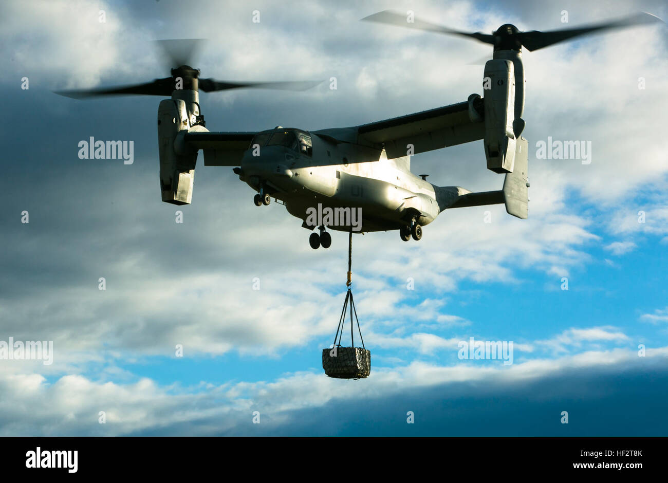 An MV-22 Osprey from Special-Purpose Marine Air-Ground Task Force Crisis Response-Africa flies with a 2180-pound pallet during an external-lift drill at Morón Air Base, Spain, Jan. 19, 2015. The unique vertical and horizontal flight capabilities make it a flexible delivery platform for Marine forces operating in the area. (U.S. Marine Corps photo by Sgt. Paul Peterson) Embracing the Whirlwind, Crisis Response Marines hone heavy-lift capabilities in Spain 150119-M-ZB219-303 Stock Photo