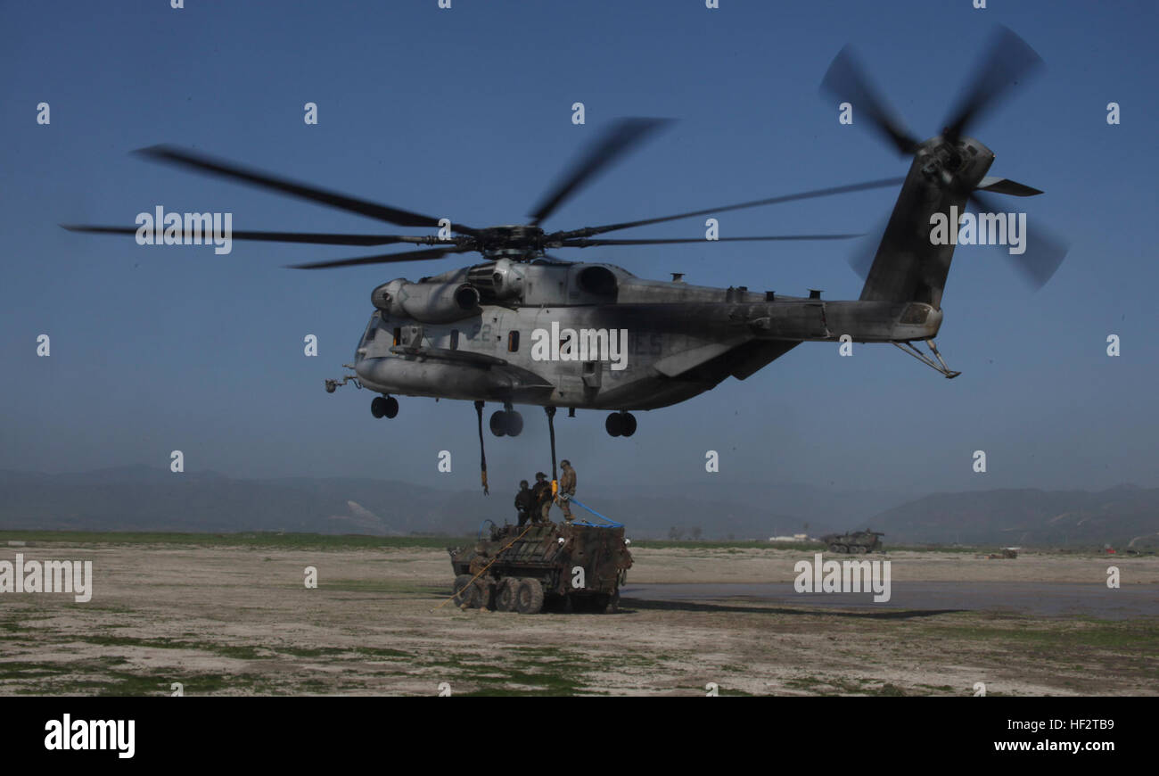 U.S. Marines with Combat Logistics Battalion 15, 15th Marine Expeditionary Unit, attach a LAV-25 light armored vehicle to a CH-53E Super Stallion during an external extract aboard Camp Pendleton, Calif., Jan. 21, 2015. The CH-53E is assigned to Marine Medium Tiltrotor Squadron 161 (Reinforced). As the 15th MEU’s combat logistics element and the air combat element respectively, CLB-15 and VMM-161 (Rein.) work together to enhance their combat skills in environments similar to those they may find in future missions. (U.S. Marine Corps photo by Cpl. Steve H. Lopez/Released) 15th MEU Marines conduc Stock Photo