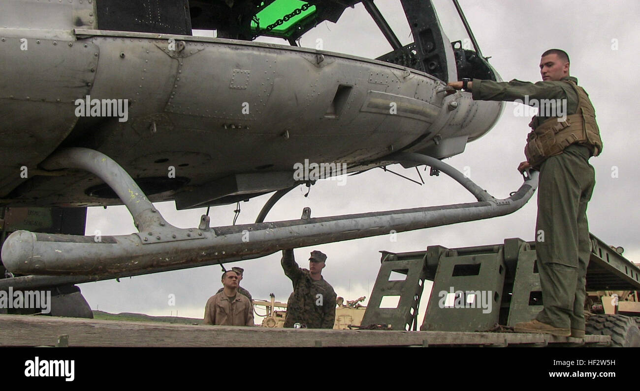 U.S. Marine Sgt. Ryan Neville, right, guides a helicopter hulk as it is placed on the back of an M870M2 trailer during a ground tactical recovery of aircraft and personnel exercise aboard Camp Pendleton, Calif., Jan. 29, 2015. Neville is a vehicle commander with Combat Logistic Battalion 15, 15th Marine Expeditionary Unit. As the 15th MEU’s combat logistics element, CLB-15 continues to hone its skills in environments similar to those they may find in future missions. (U.S. Marine Corps photo by Cpl. Steve H. Lopez/Released) 15th MEU Marines conduct ground TRAP training 150129-M-TJ275-071 Stock Photo
