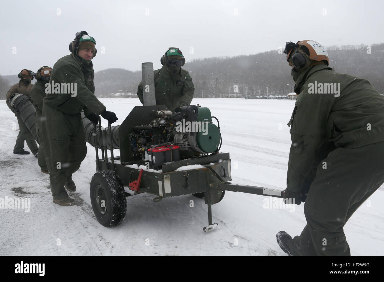 Marines with Marine Heavy Helicopter Squadron 464 transport a preheater to a CH-53 Super Stallion to warm up the engines before powering them up during the squadron’s deployment for training exercise aboard Camp Dawson, W. Va., Jan. 30, 2015. The squadron battled heavy snowfall during the beginning of their exercise, and they took the proper precautions to counteract the inclement weather. HMH-464 battle cold weather during DFT 150130-M-FD819-751 Stock Photo