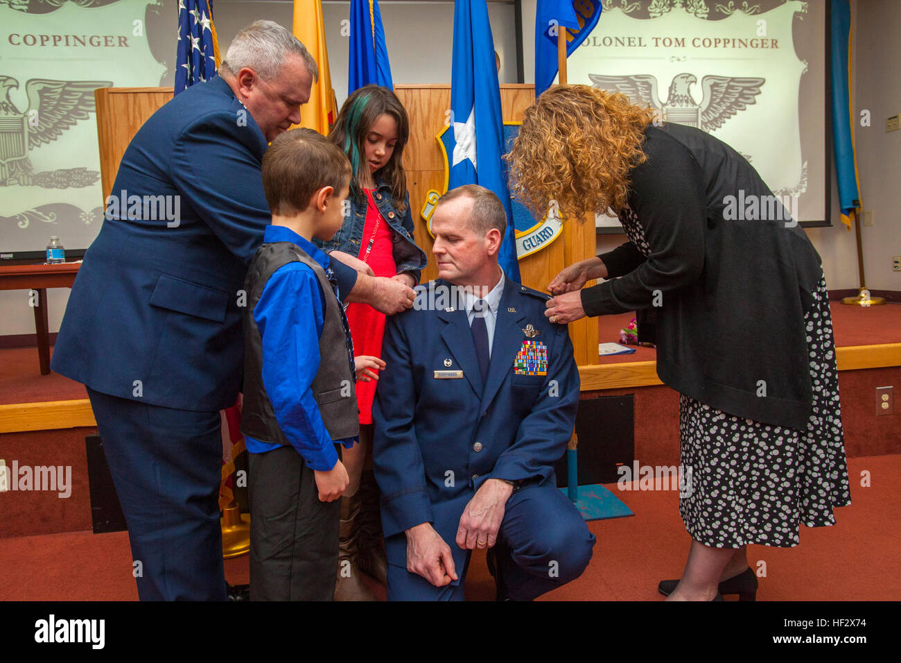 Brig. Gen. Michael L. Cunniff, left, the adjutant general of New Jersey, assists Lt. Col. Thomas P. Coppinger’s wife Alane, right, and their children, Aidan, second from left, and Melissa, in properly attaching the colonel’s eagles on their father’s epaulets during an Assumption of Command and promotion ceremony at Joint Base McGuire-Dix-Lakehurst, N.J., Feb. 8, 2015. The 108th Operations Group is part of the 108th Wing, New Jersey Air National Guard. (U.S. Air National Guard photo by Master Sgt. Mark C. Olsen/Released) Coppinger assumes command of Operations Group 150208-Z-AL508-041 Stock Photo