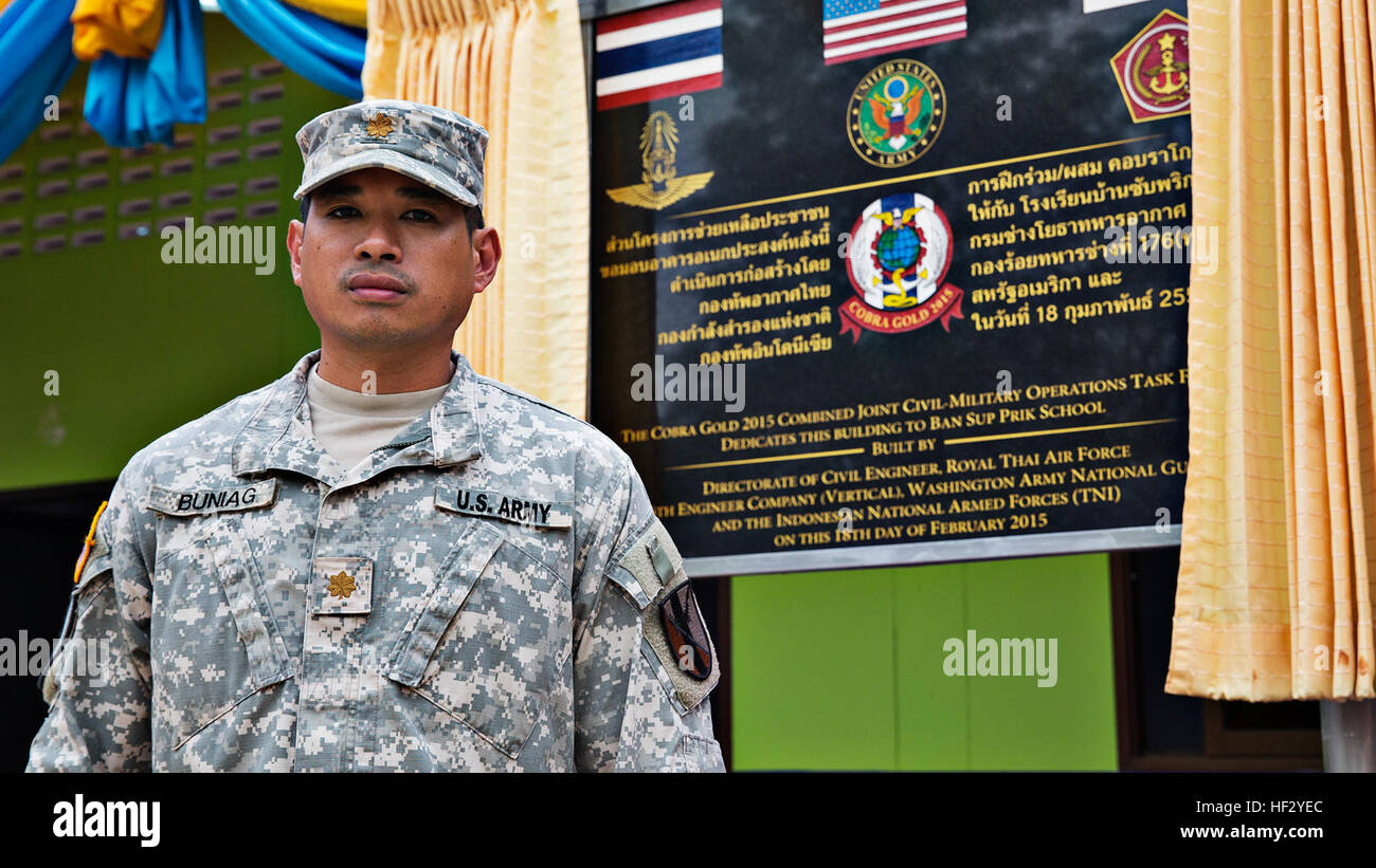 U.S. Army Maj. Alejandro Buniag, deputy commander of the Combined Joint Civil-Military Task Force element of Exercise Cobra Gold 2015, and a native of Yigo, Guam, stands before the commemorative plaque of a new multipurpose facility at Ban Sub Prik Elementary School, located in Muak Lek District, Saraburi Province, Thailand, on Feb. 18. As part of CG15, a multinational force of Royal Thai Air Force, Indonesian Marine Corps and U.S. Army engineers began constructing the new building at Ban Sub Prik in mid-January. The facility will serve as a classroom, community center and hallmark of 182 year Stock Photo