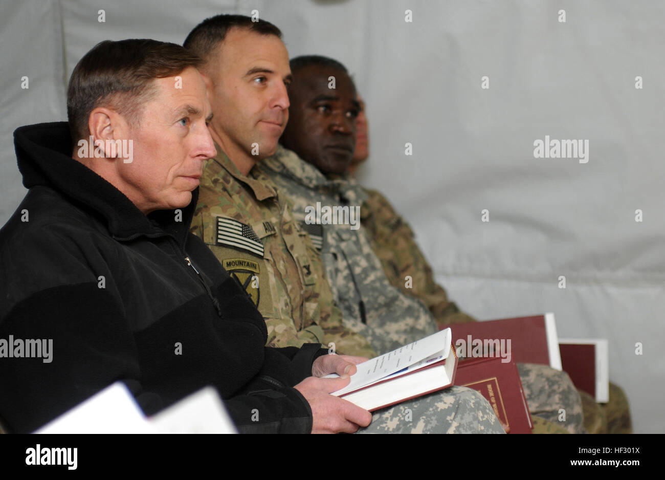 LOGAR Province, Afghanistan - U.S. Army Gen. David H. Petraeus (left), International Security Assistance Force commanding general from Cornwall on Hudson, N.Y., listens to a Christmas Eve sermon from U.S. Army Chaplain Capt. Jeff Bernard, battalion chaplain for 94th Brigade Support Battalion, 4th Brigade Combat Team, 10th Mountain Division from ???? during a candlelight service on Forward Operating Base Shank, Afghanistan, Dec. 24., From left, sitting in the row with Petraeus are U.S. Army Col. Bruce P. Antonia, commander of 4th BCT, 10th Mtn. Div. from Manchester, Conn.; U.S. Army Command Sgt Stock Photo