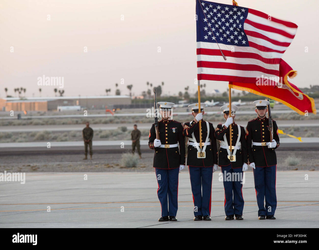 As part of the annual Yuma Airshow, the Marine Corps Air Station Yuma, Ariz., color guard carry the colors during the Twilight Show’s national anthem at the station flight line, Friday, Feb. 27, 2015. MCAS Yuma Twilight Show 150227-M-HL954-081 Stock Photo
