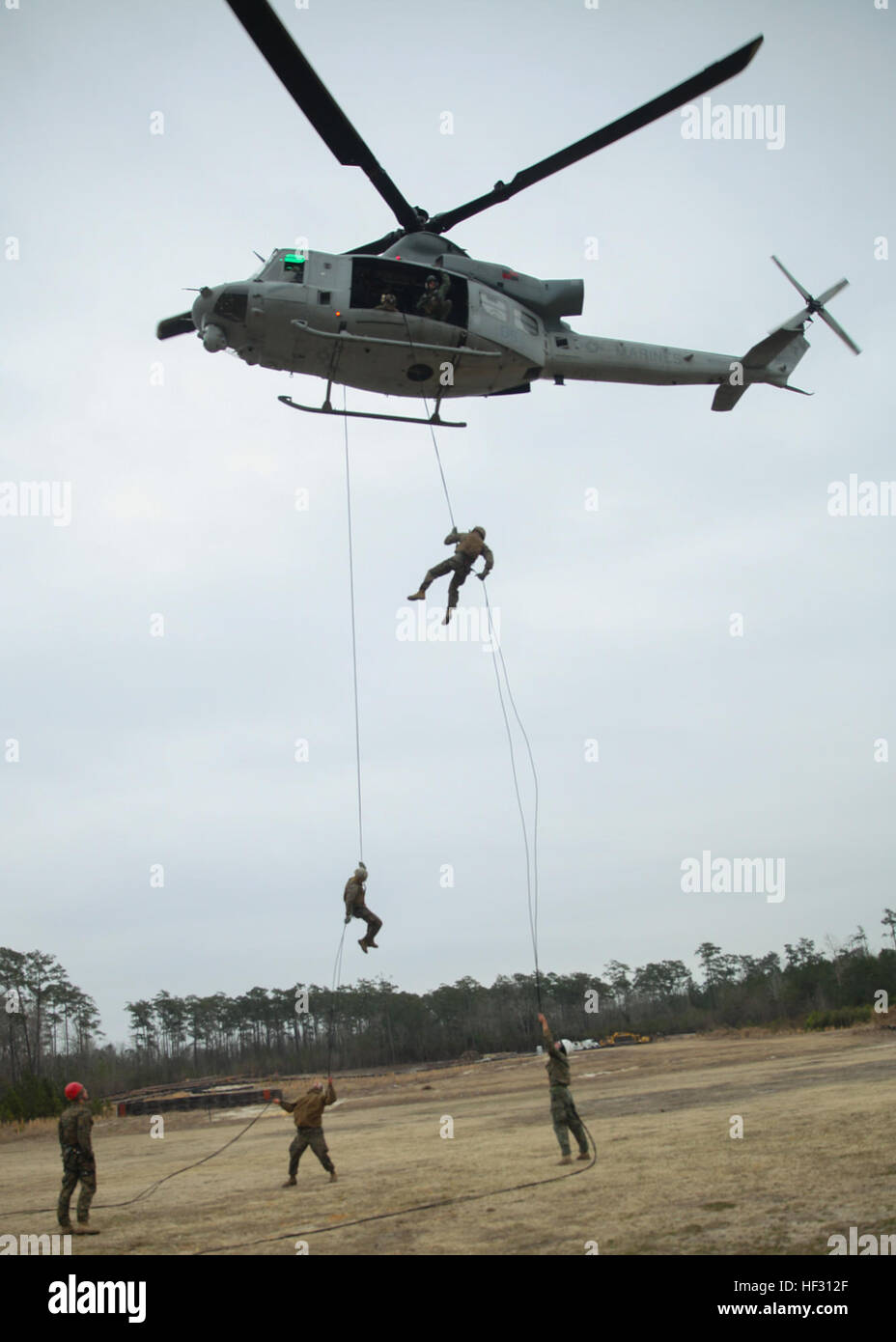 Students rappel from a helicopter during the Helicopter Ropes Suspension Techniques course taught by Expeditionary Operations Training Group March 3, 2015, at Stone Bayaboard Marine Corps Base Camp Lejeune, N.C. The 10-day course teaches Marines to become subject-matter experts at controlling fast-rope or rappelling exercises and units with HRST capabilities make it possible to insert or extract Marines from an area where landing an aircraft would be impractical. (Marine Corps photo by Cpl. Michelle Reif/released) Marines learn to master the ropes during helicopter suspension techniques course Stock Photo