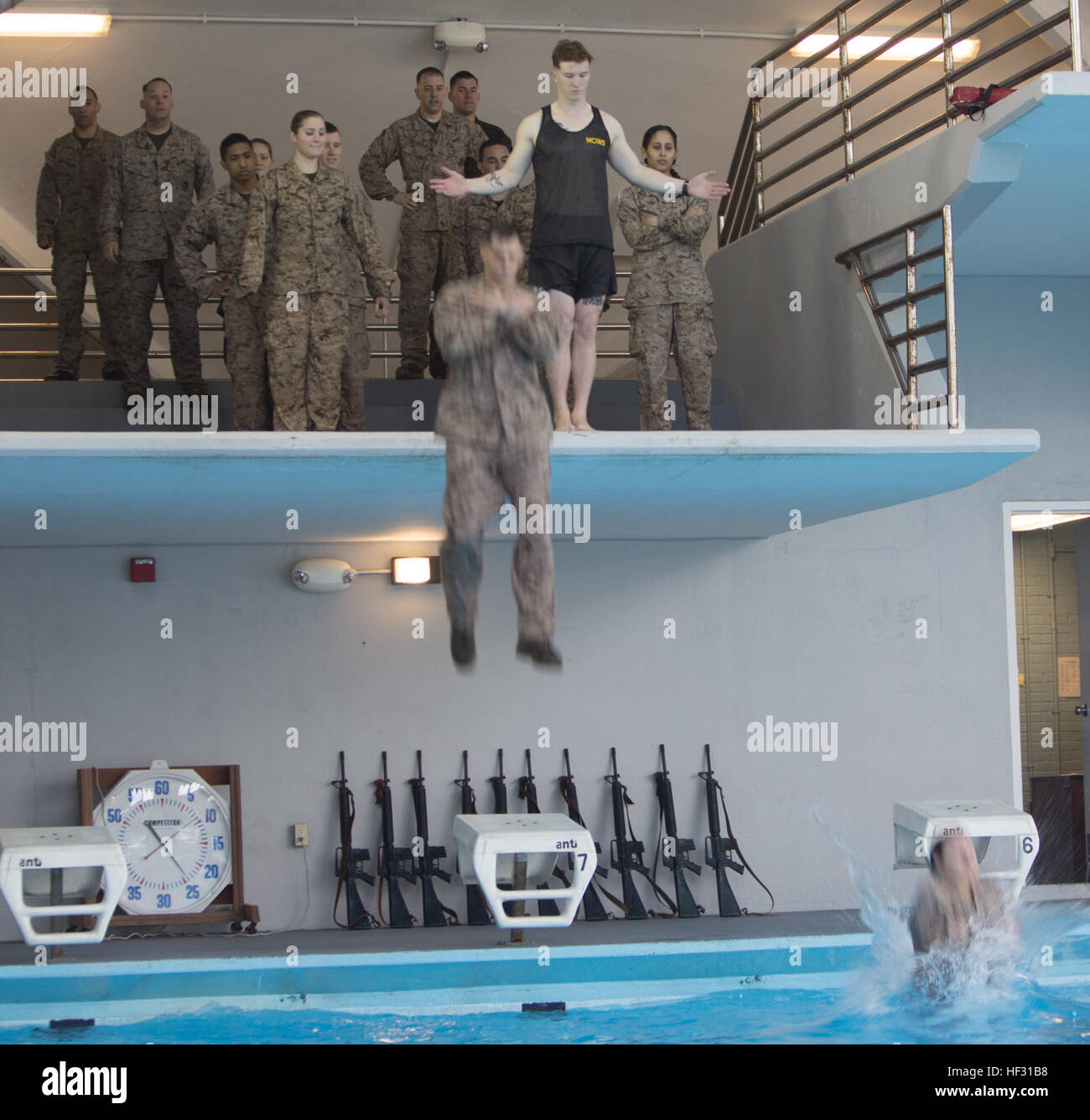 Two Marines step off an eight foot platform into the water during a swim qualification aboard Marine Corps Base Camp Lejeune, March 5, 2015. Marines have to get re-certified in water survival every two years on active duty, or every three years if they pass the intermediate swim qualification. (Official Marine Corps photo by Cpl. Scott W. Whiting) Marines get their feet wet during swim qualification 150305-M-FD819-578 Stock Photo