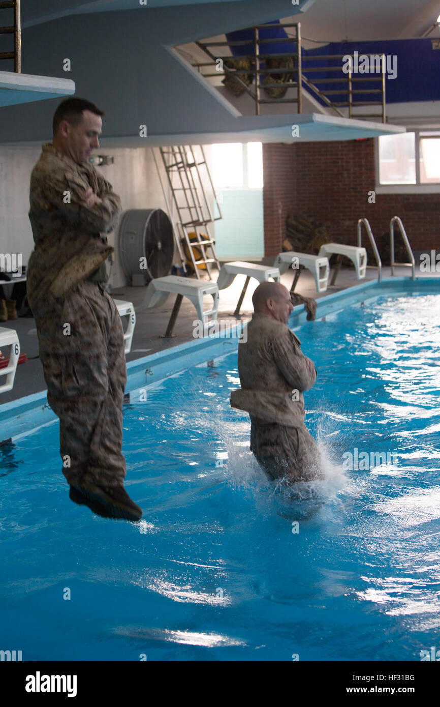 Two Marines step off an eight foot platform into the water during a swim qualification aboard Marine Corps Base Camp Lejeune, March 5, 2015. Marines have to get re-certified in water survival every two years on active duty, or every three years if they pass the intermediate swim qualification. (Official Marine Corps photo by Cpl. Scott W. Whiting) Marines get their feet wet during swim qualification 150305-M-FD819-705 Stock Photo