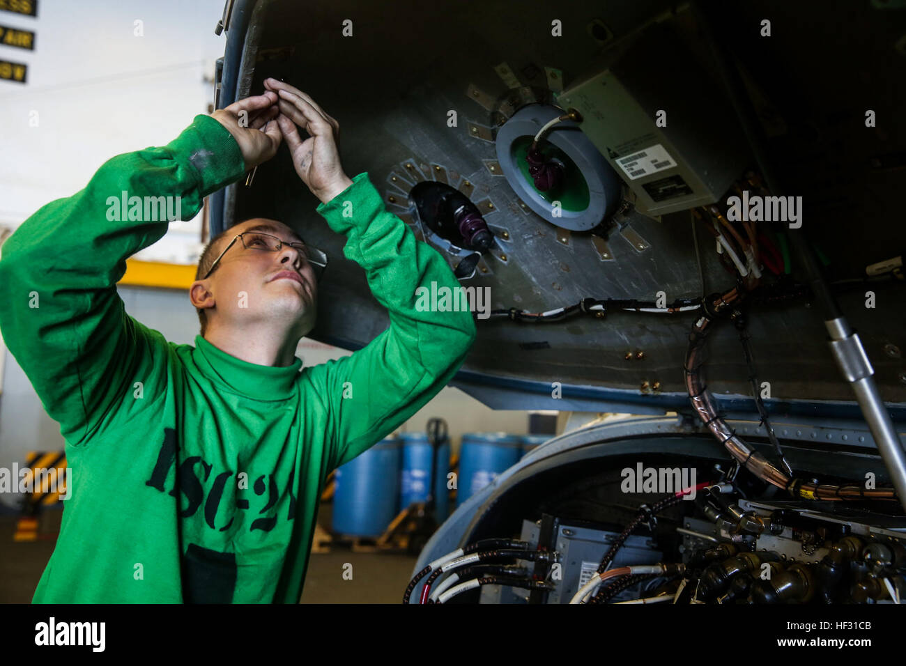 U.S. Navy Seaman Wesley Huddleston does daily maintenance on an MH-60S Seahawk aboard the USS Essex (LHD 2) during Amphibious Squadron/Marine Expeditionary Unit Integration Training (PMINT) off the coast of San Diego March 5, 2015. Huddleston is an aviation electrician’s mate with the Essex Amphibious Ready Group. Marines and Sailors work side-by-side to ensure their aircraft is in the best condition possible. (U.S. Marine Corps photo by Cpl. Anna Albrecht/Released) USS Essex, Maintenance at sea 150305-M-SV584-003 Stock Photo